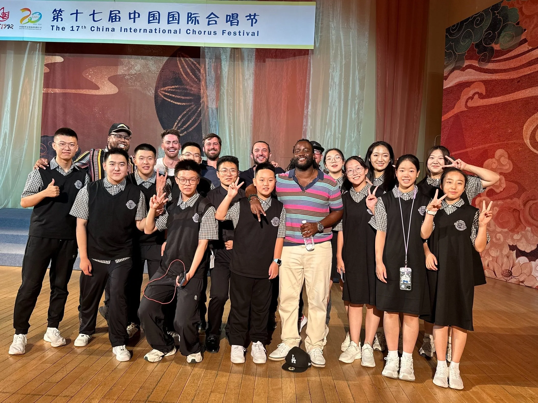 Group photo at the 17th China International Chorus Festival featuring participants in uniform on a stage.