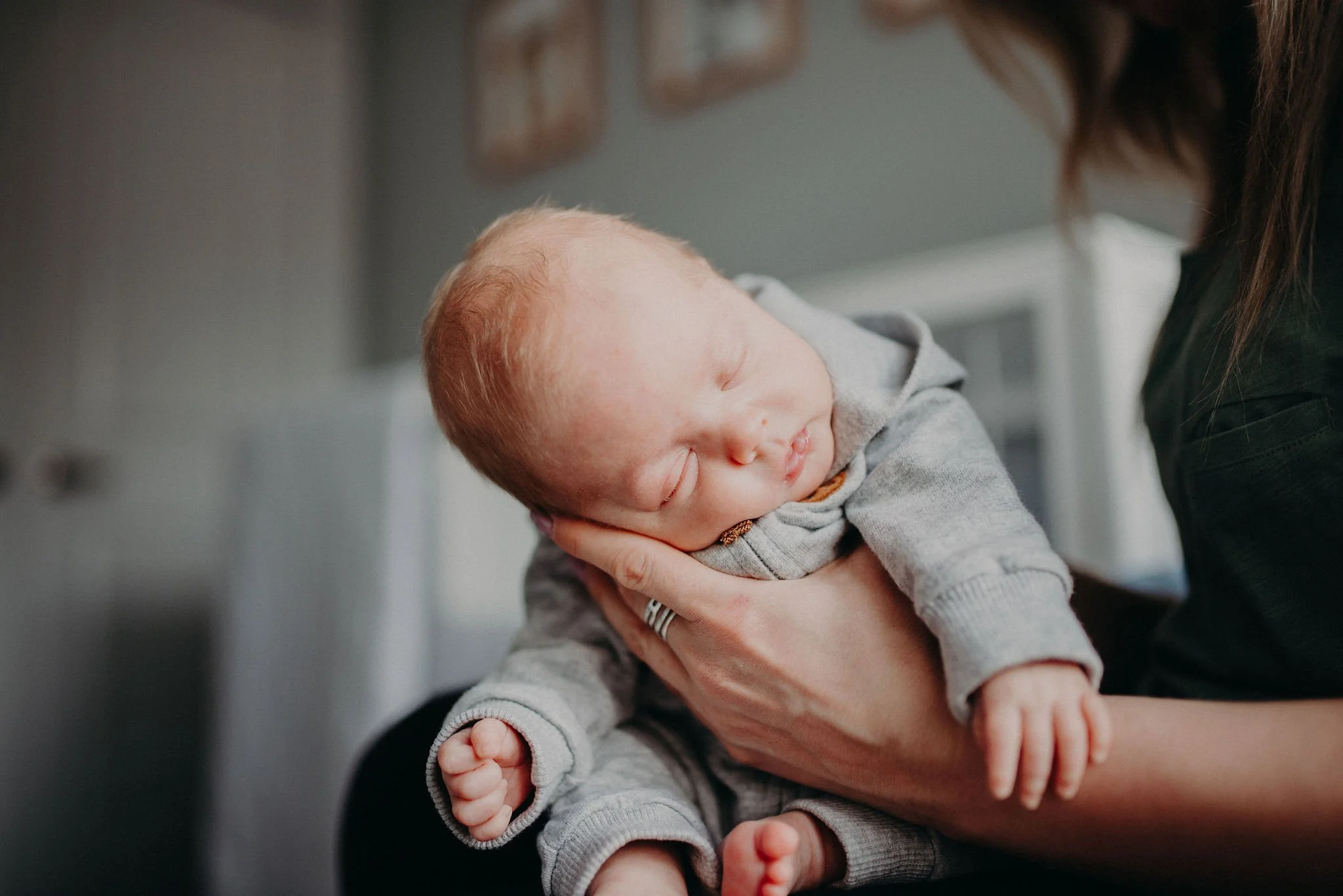 Postpartum doula assisting with light household tasks while supporting a family with their newborn