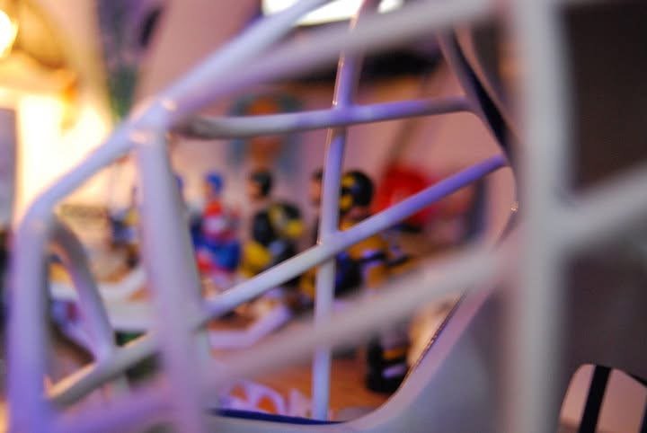 Close-up of a sports game miniature figure collection behind a metallic railing.