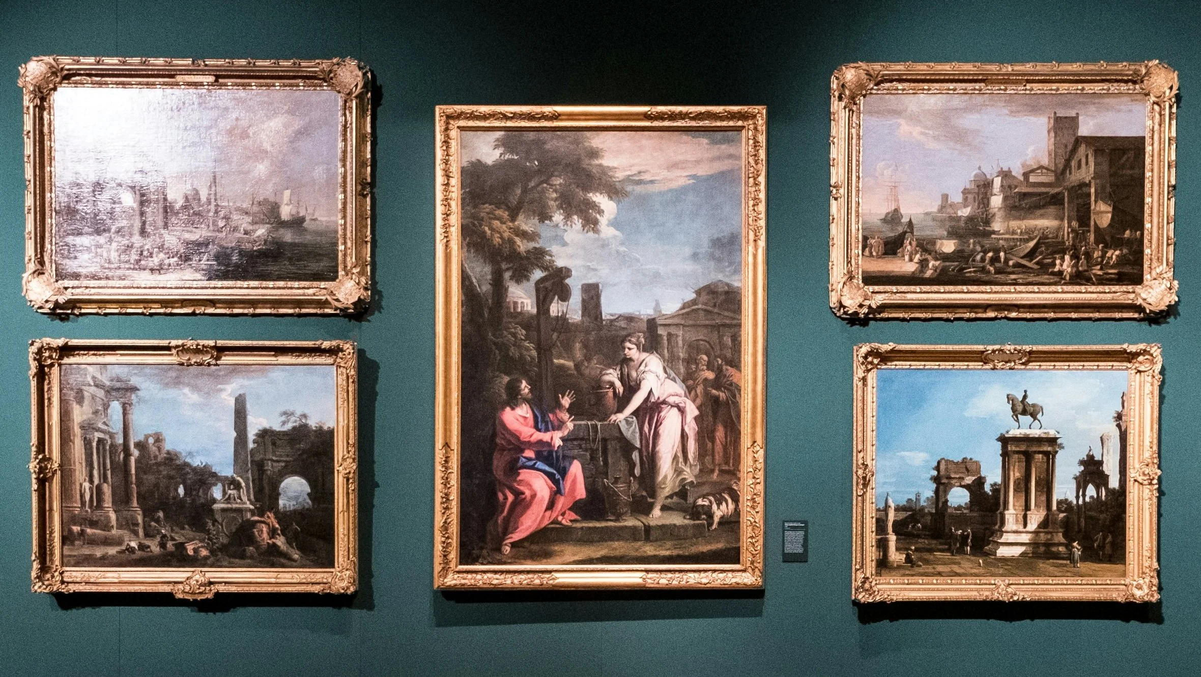 Well Well What a gift - Five landscape paintings in ornate gold frames displayed on a teal gallery wall.