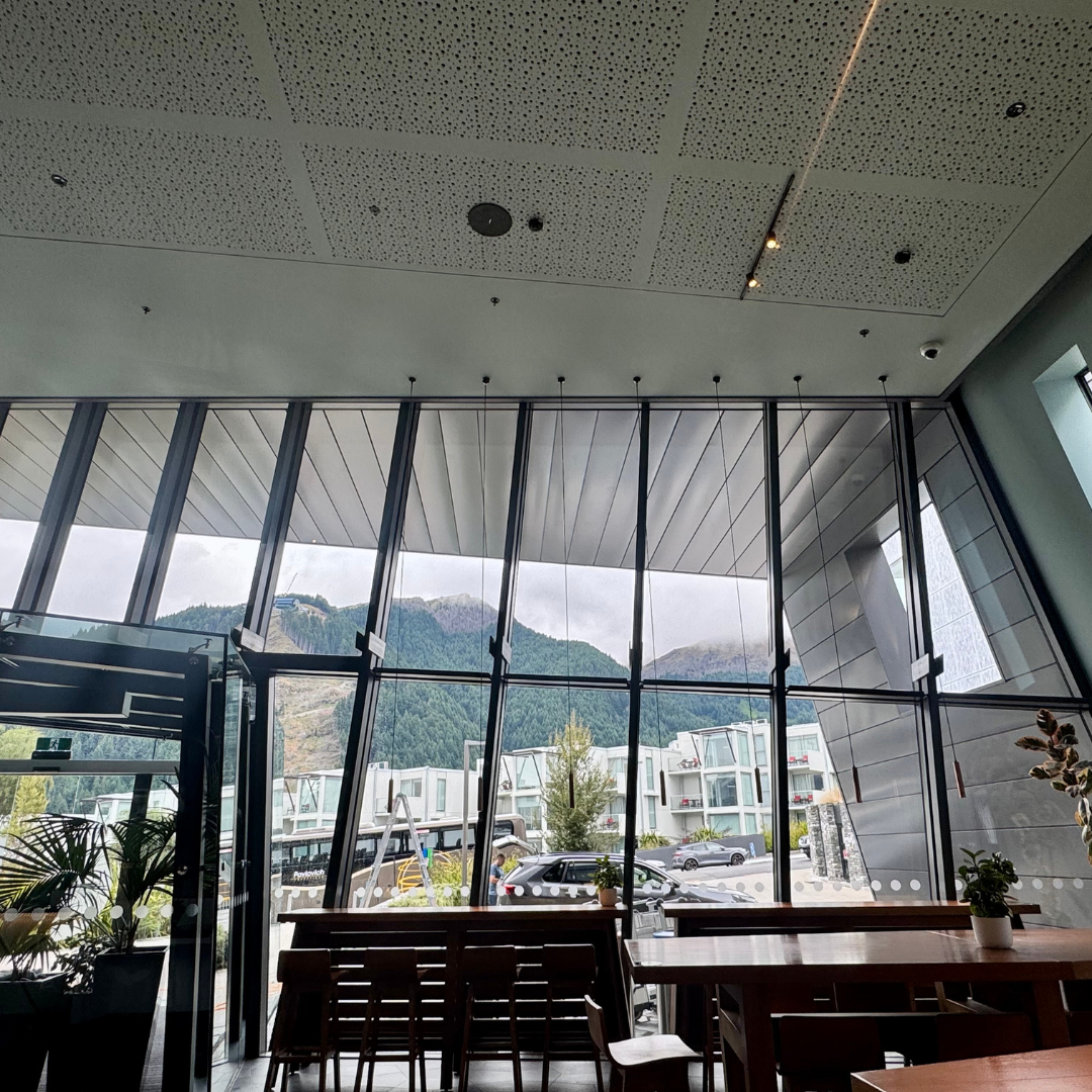 Commercial interior window cleaning with a squeegee removing fingerprints and marks from glass doors.