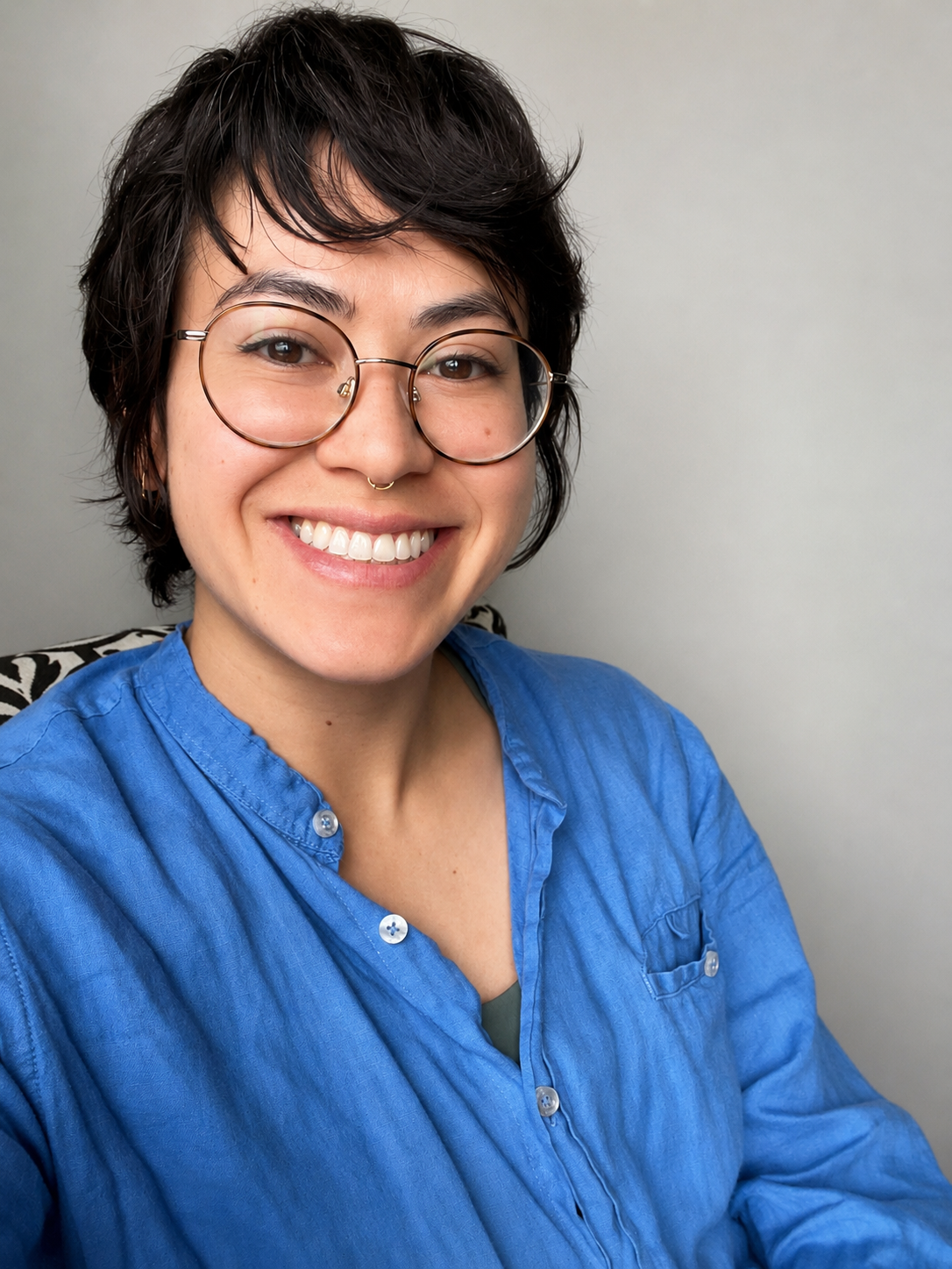 A photo of me wearing a blue shirt, smiling, and wearing glasses.