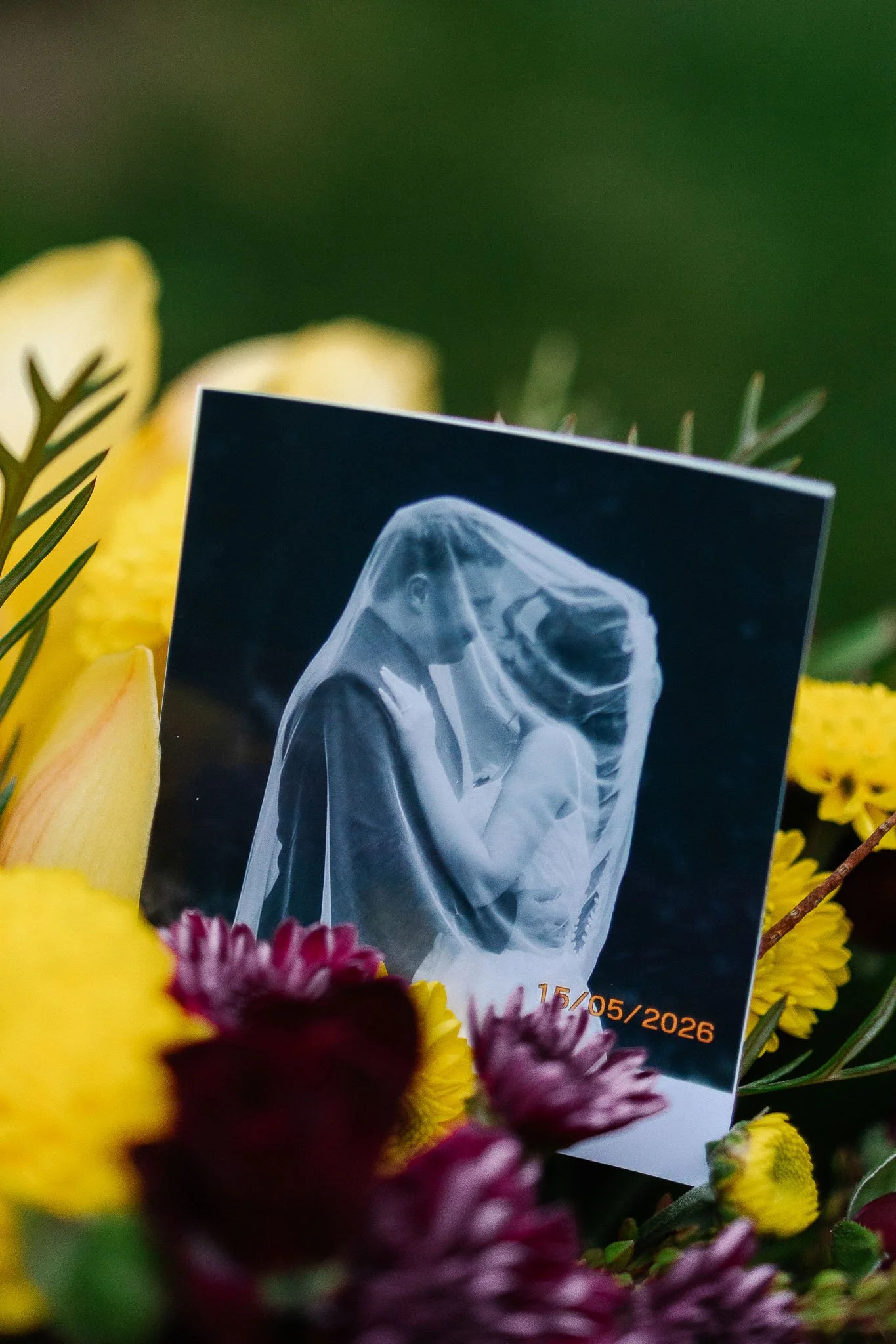 Printed wedding portrait of Gabriella and Jan displayed among colourful flowers