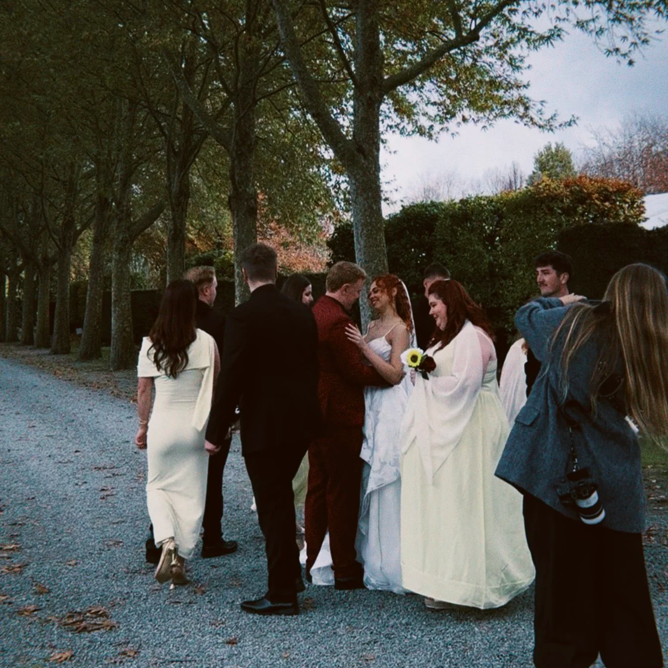 Newlyweds and wedding guests gathered beneath the trees at Trott’s Garden