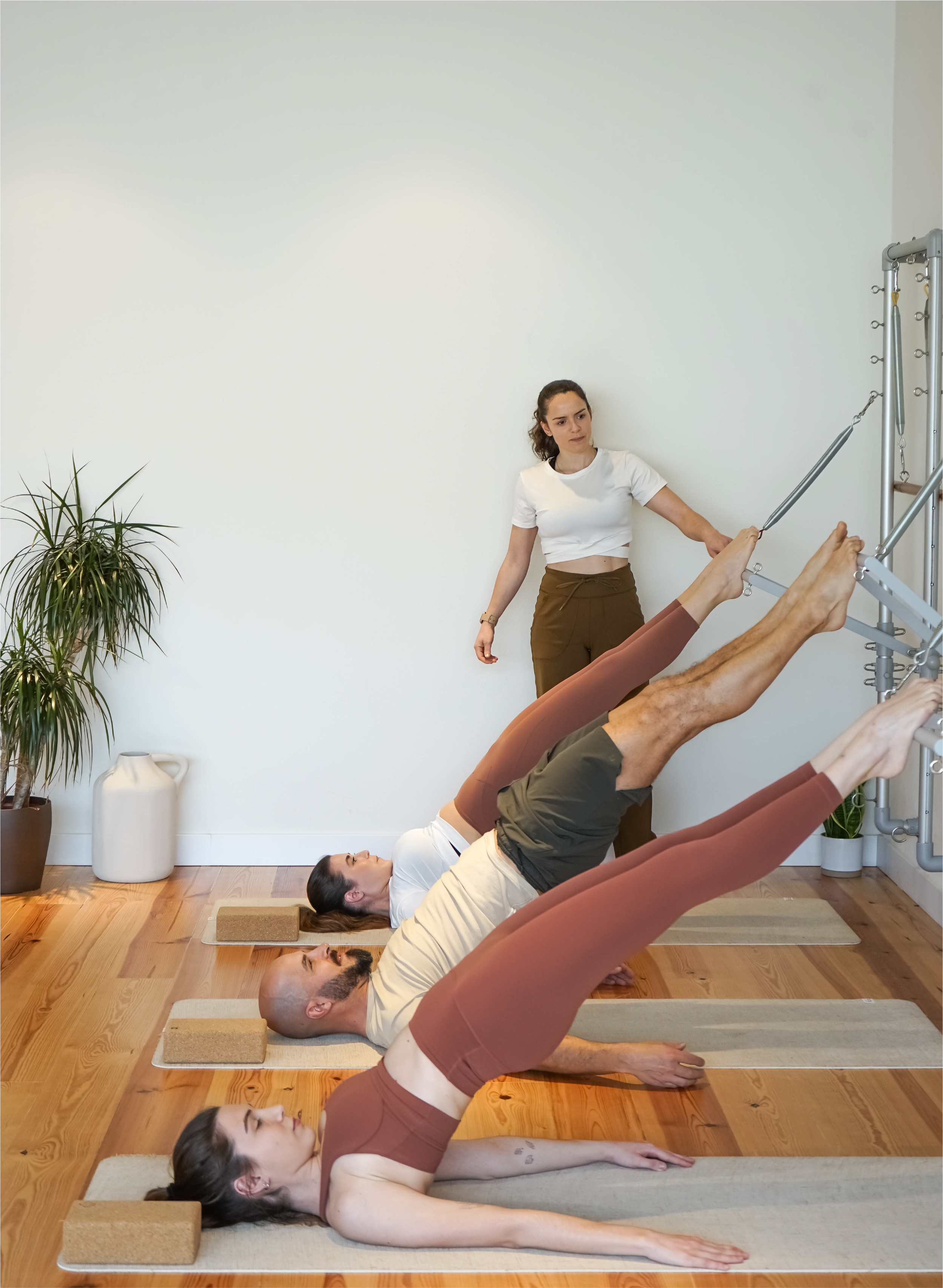 Aula de Pilates em trio no estúdio de Marvila, Lisboa, com três alunos em wall unit.