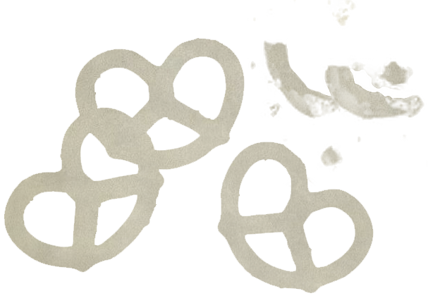 Three pretzels on a piece of paper with some crumpled tissue or napkin in the background.