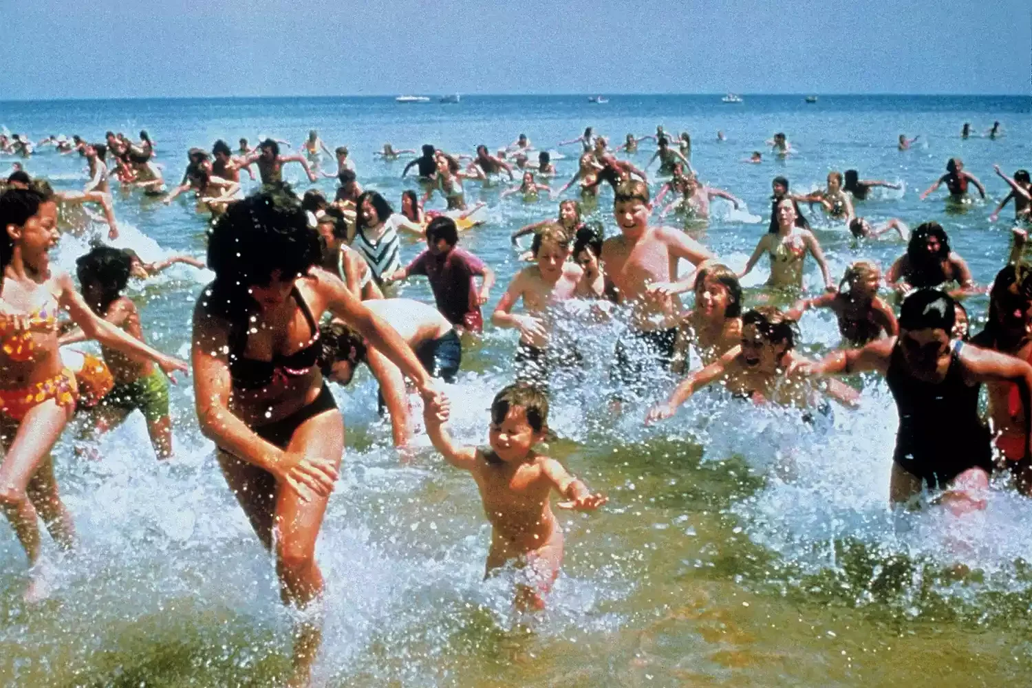 people at the beach running from the water