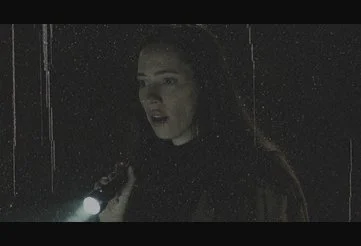 Beth investigating her isolated lakeside home at night with a flashlight