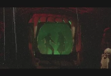 Amy and Buzz walk through one of the glowing, interactive rooms in The Funhouse