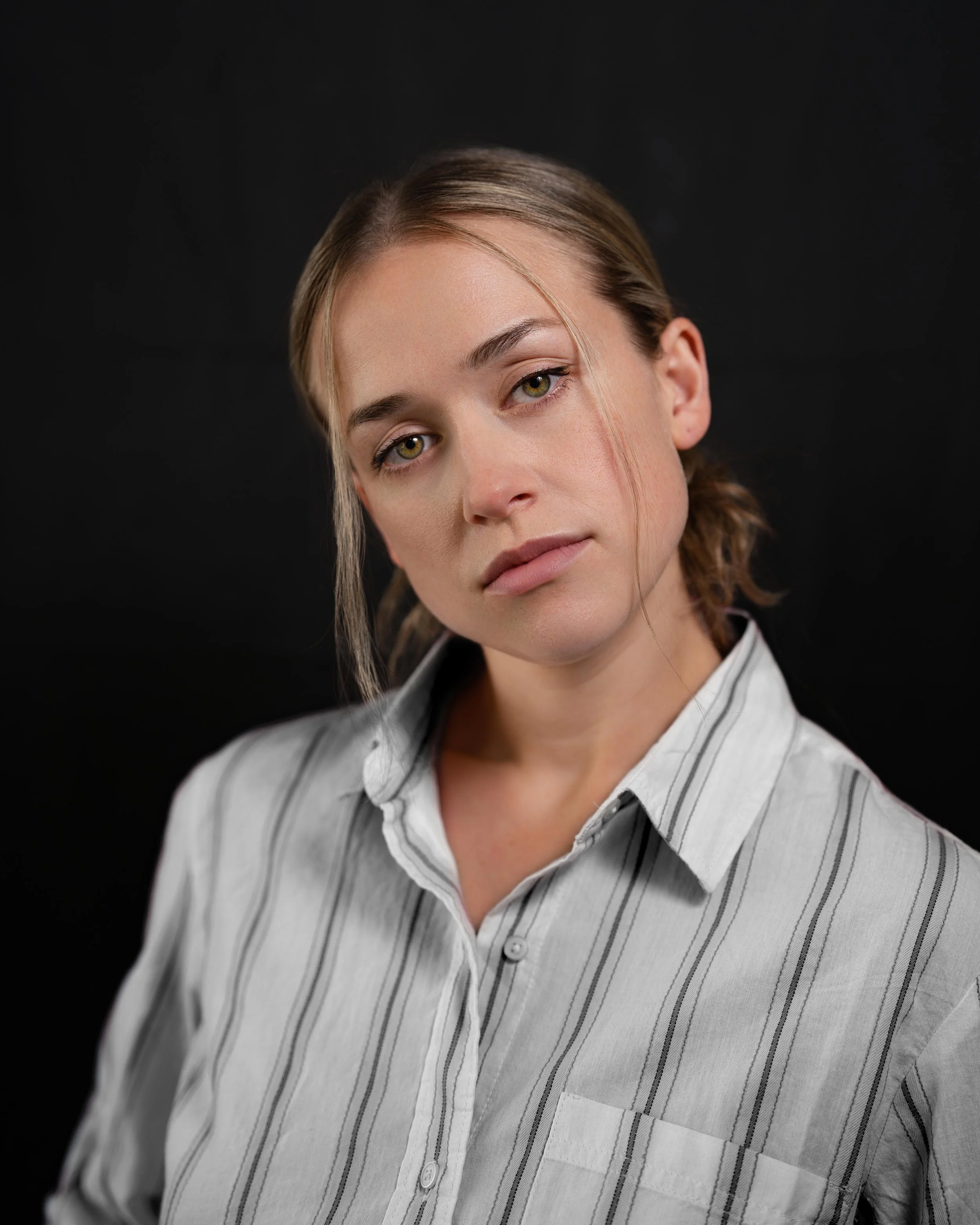 Portrait headshot of female actor looking sensually at camera with white striped shirt