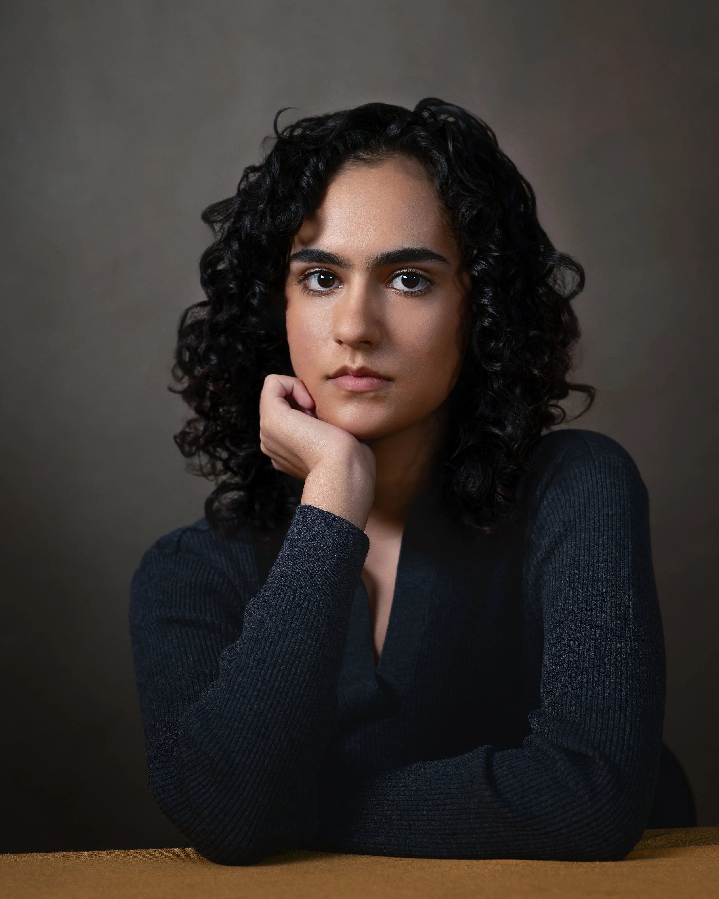 Portrait of brown actor sitting at yellow table