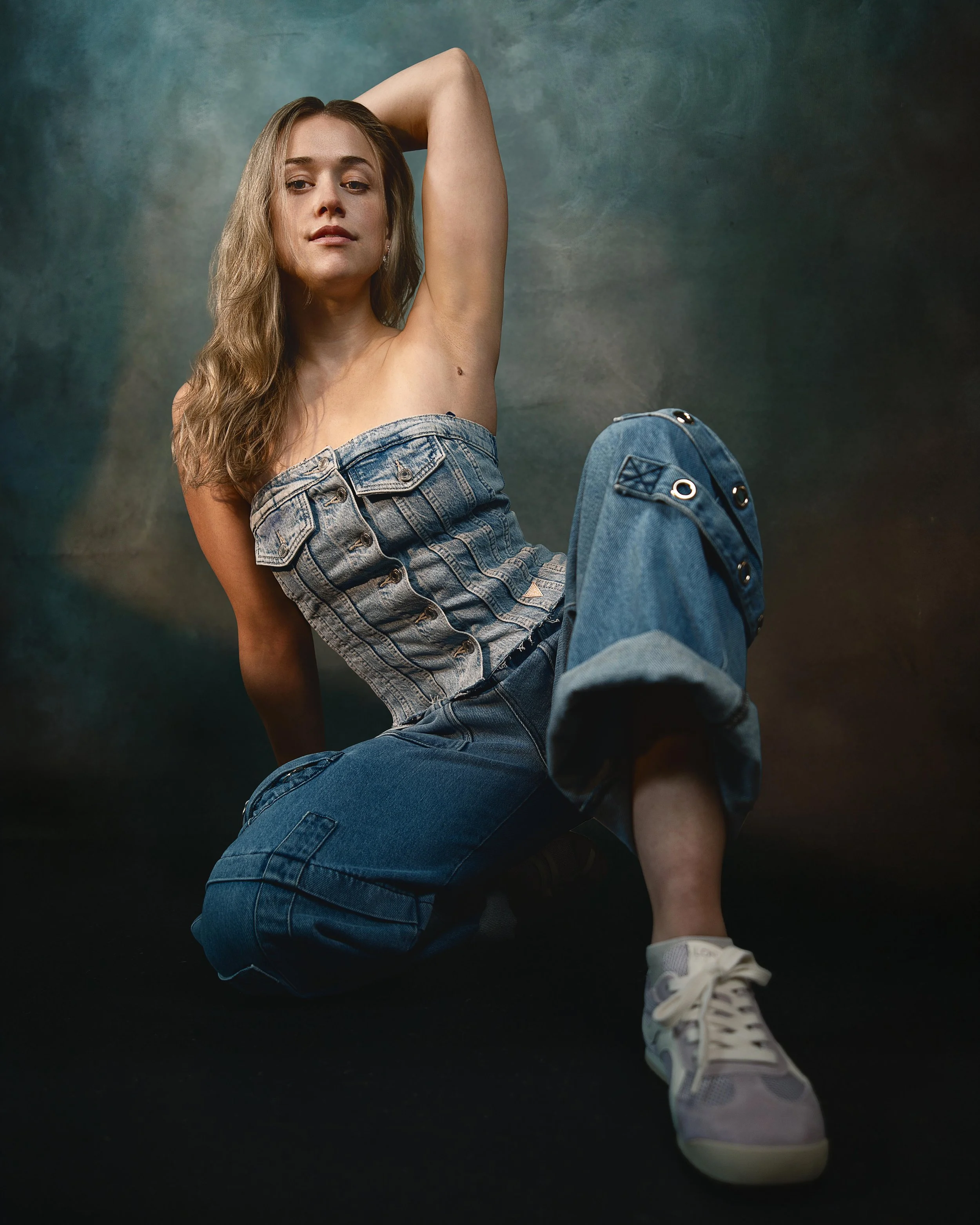 Portrait headshot of female actor in blue jeans and blue tude top