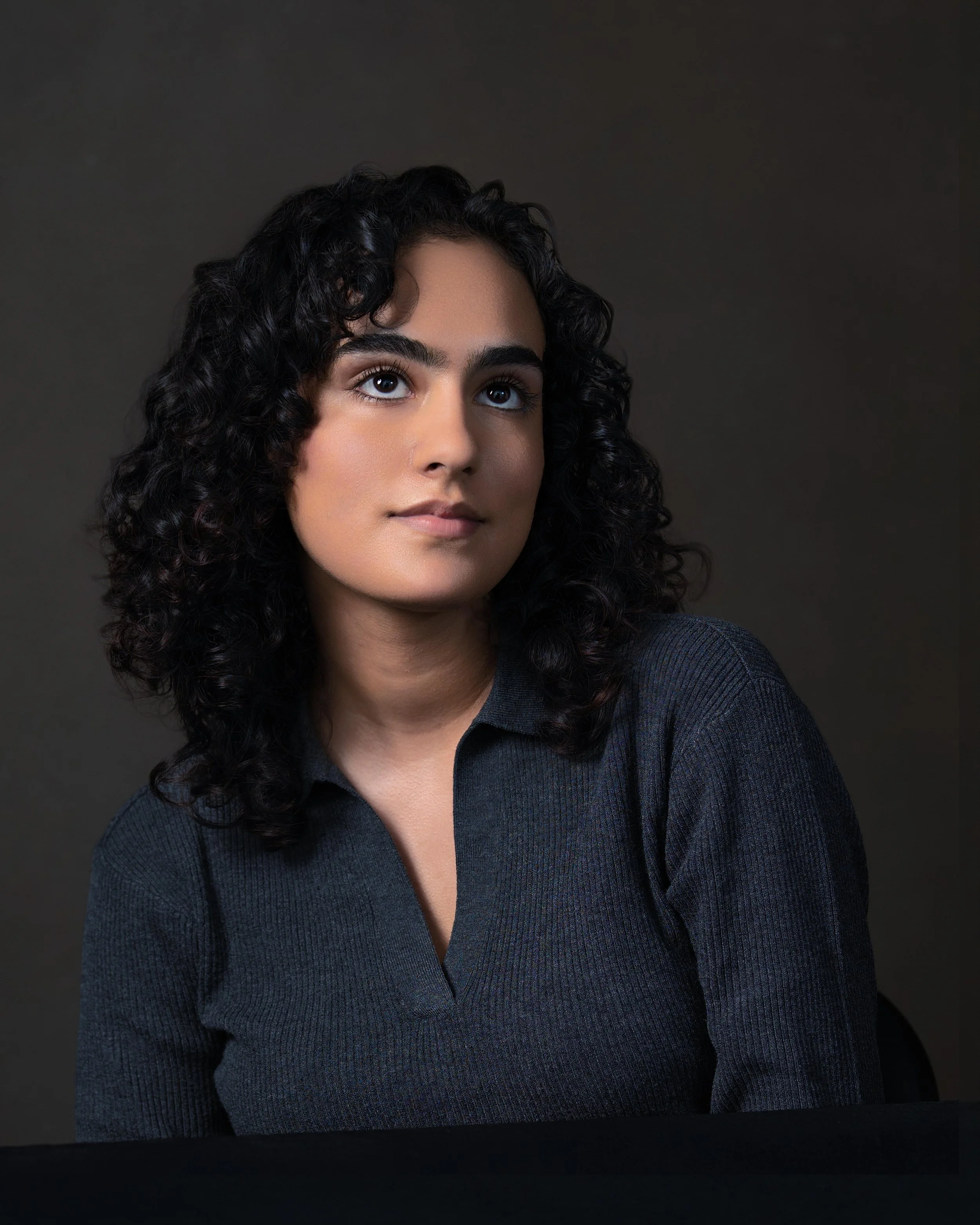 Headshot of brown woman looking up