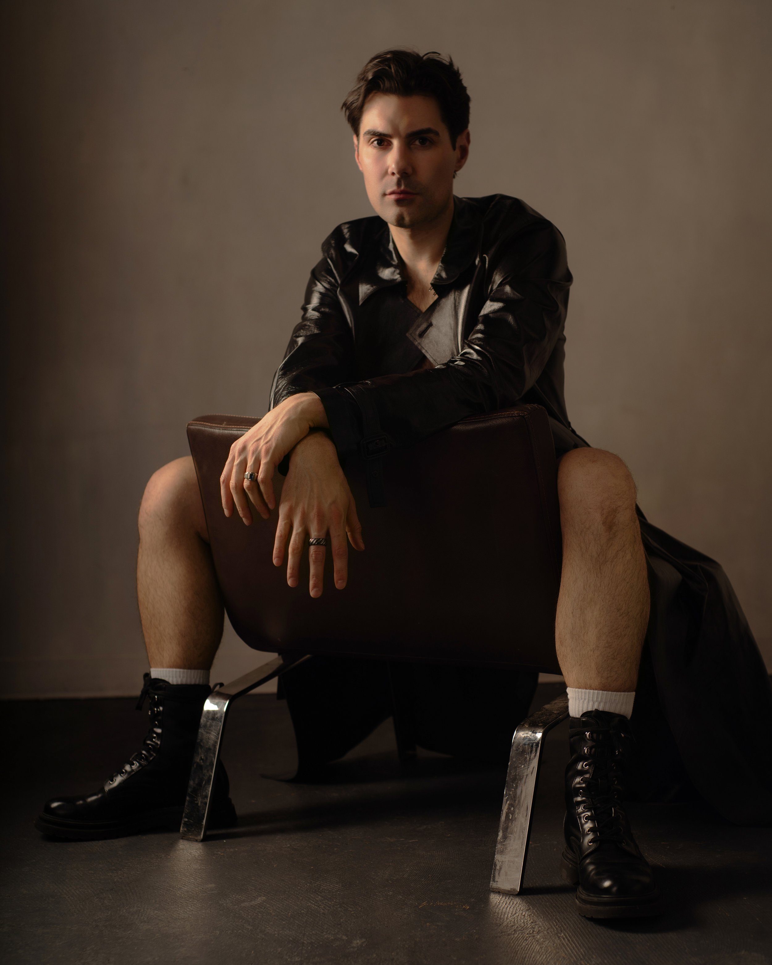 Portrait of a man sitting backwards in vintage chair