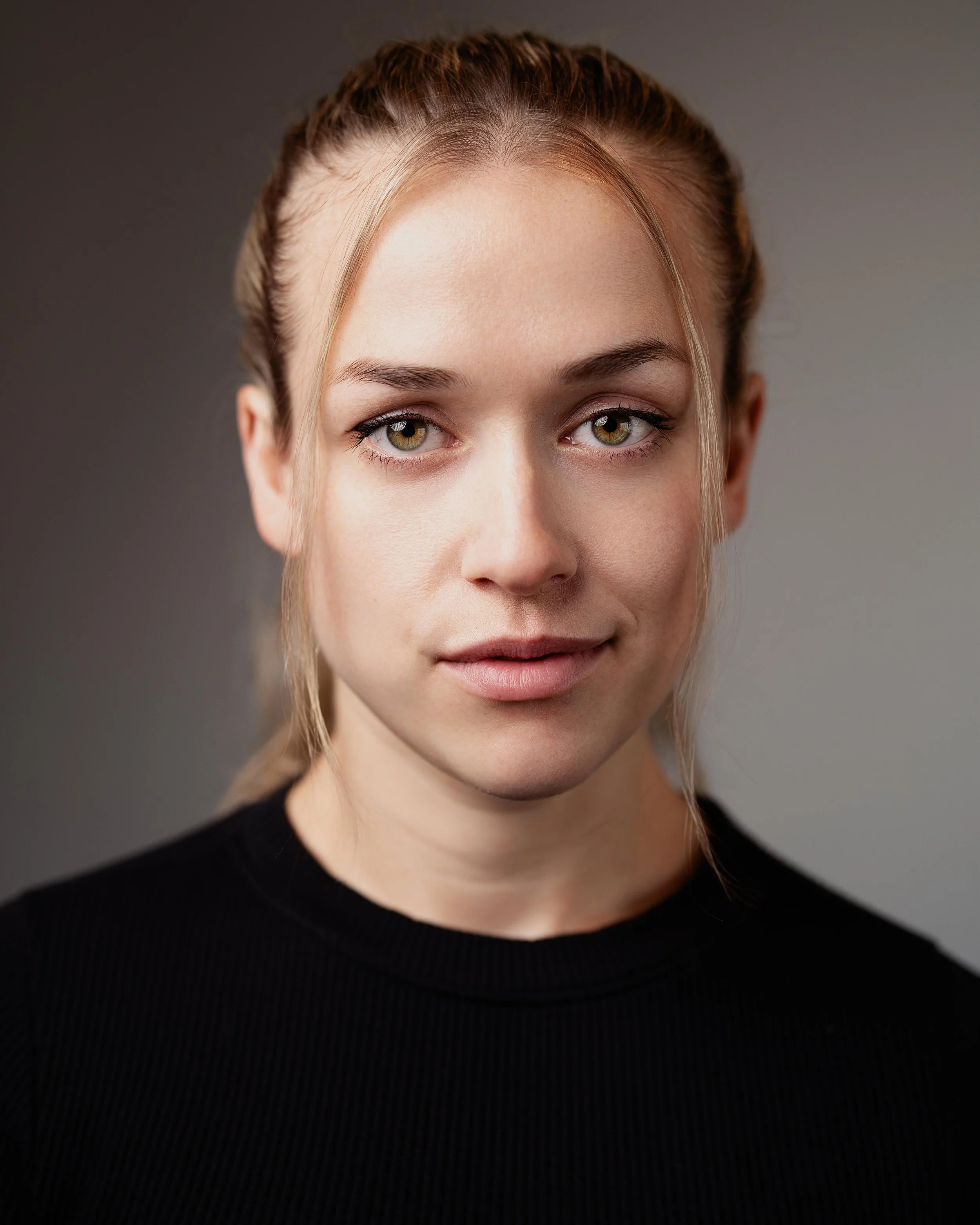 Portrait headshot of female actor in black with hair up