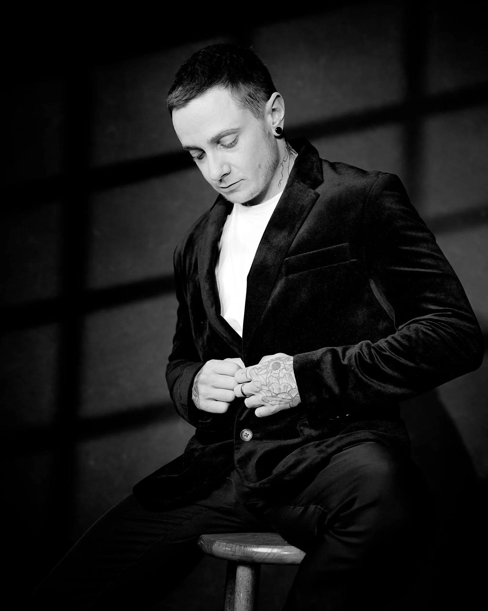 black and white portrait of a man buttoning up jacket