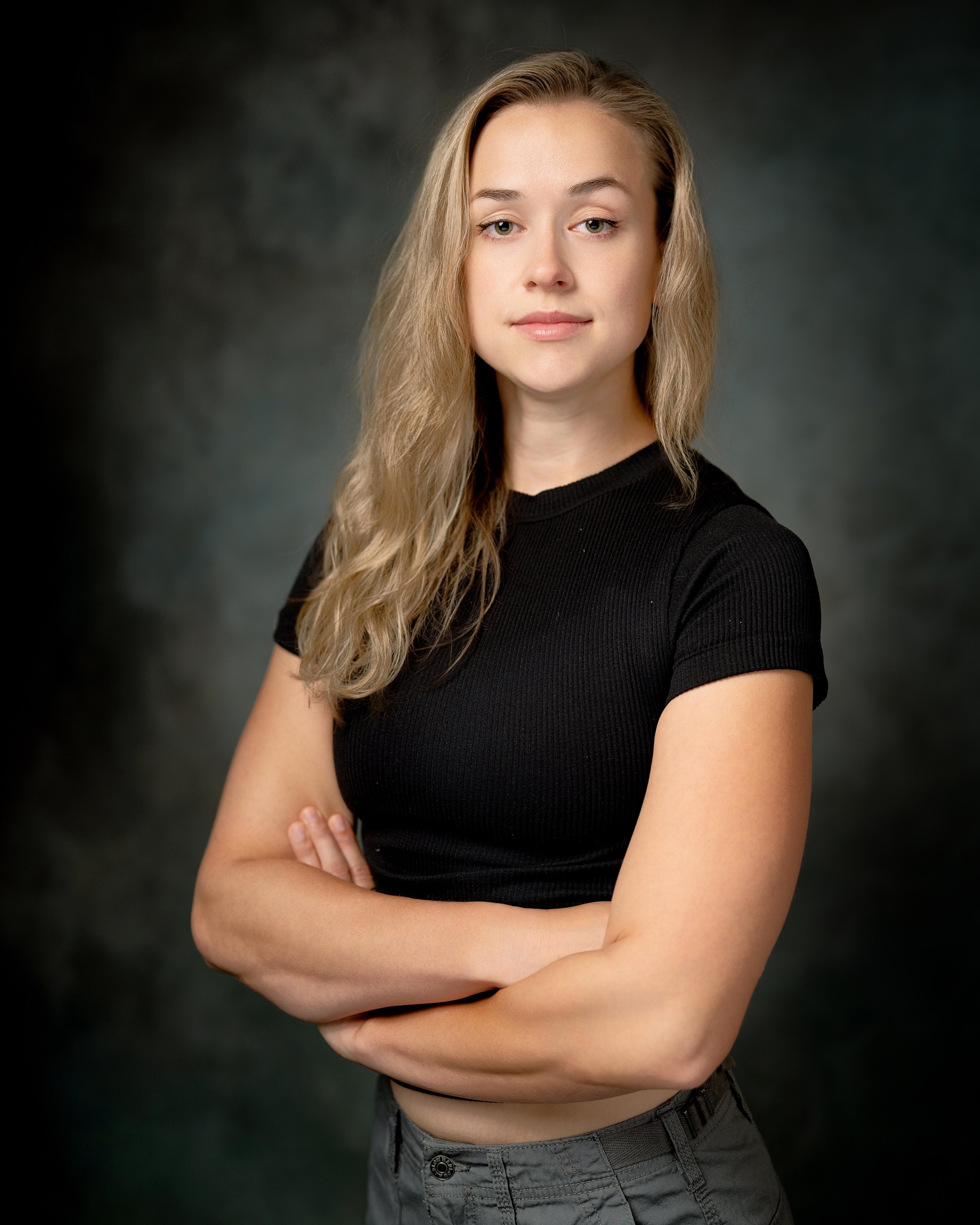 Portrait headshot of female actor black shirt and cloudy backdrop stuntwoman