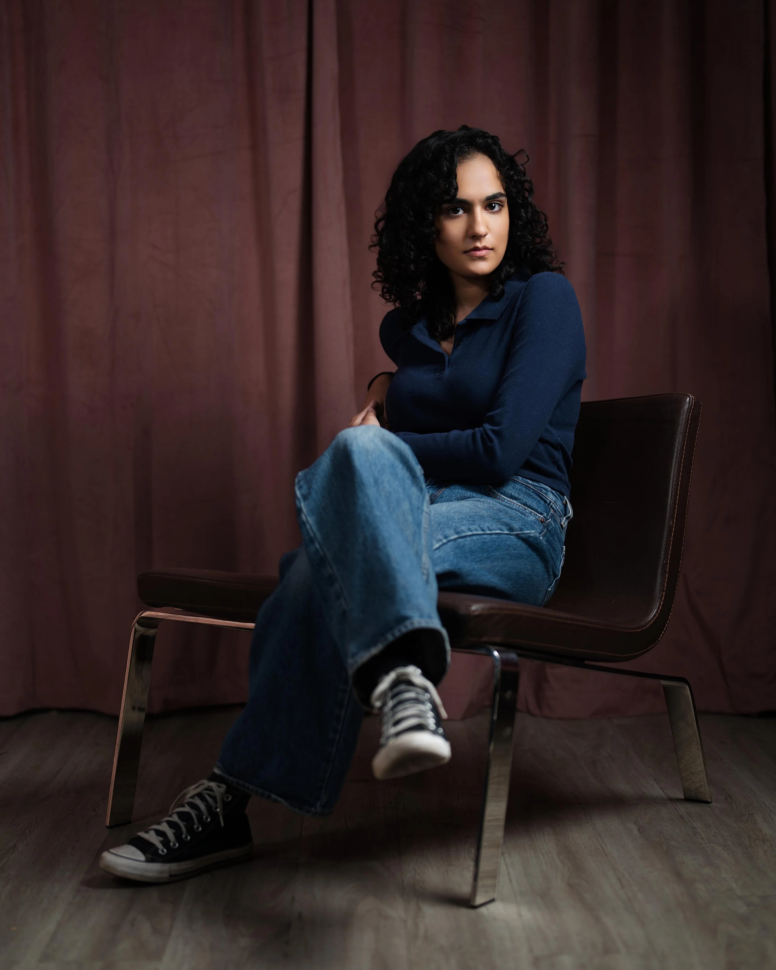 Portrait of brown woman sitting in brown leather chair