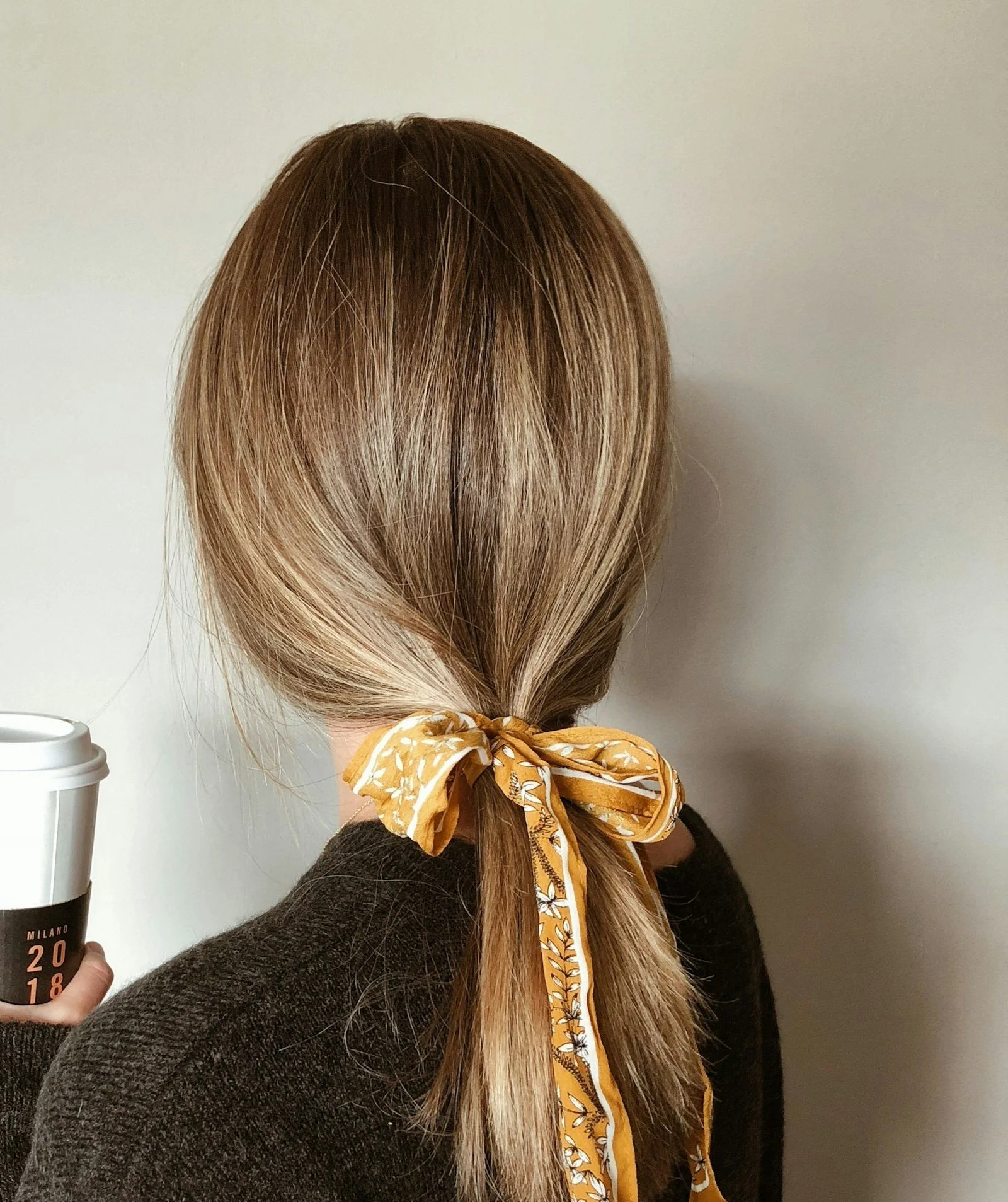 smooth hair in a hair bow holding a coffee