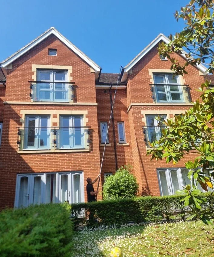 Professional gutter clearing service for property manager on three-storey residential property using extendable pole — Sphere Cleaning Services
