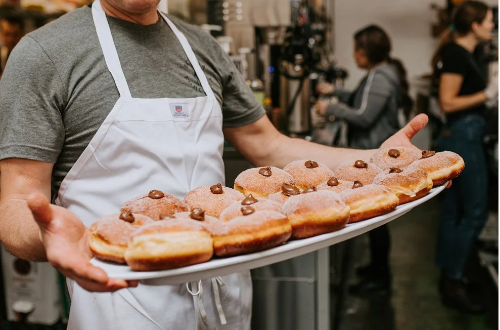 Cook holding platter of doughnuts