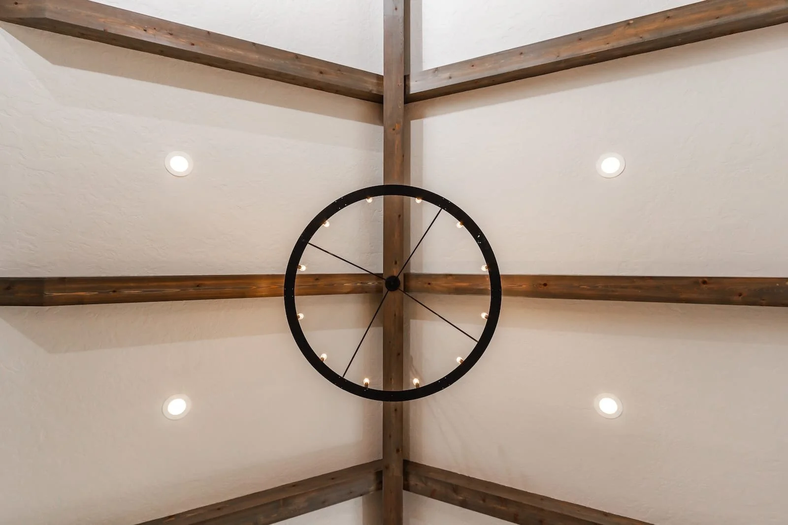 Eagle Idaho - Wooden beam ceiling with circular wagon wheel chandelier and recessed lights.
