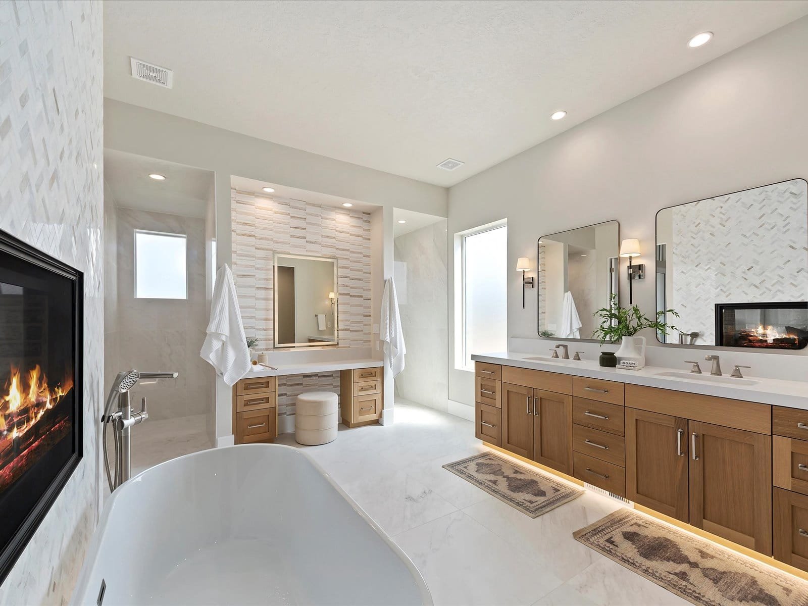 Eagle, Idaho Homes, LLC - Luxury bathroom with freestanding tub, dual vanity, modern fireplace, and spacious shower area.