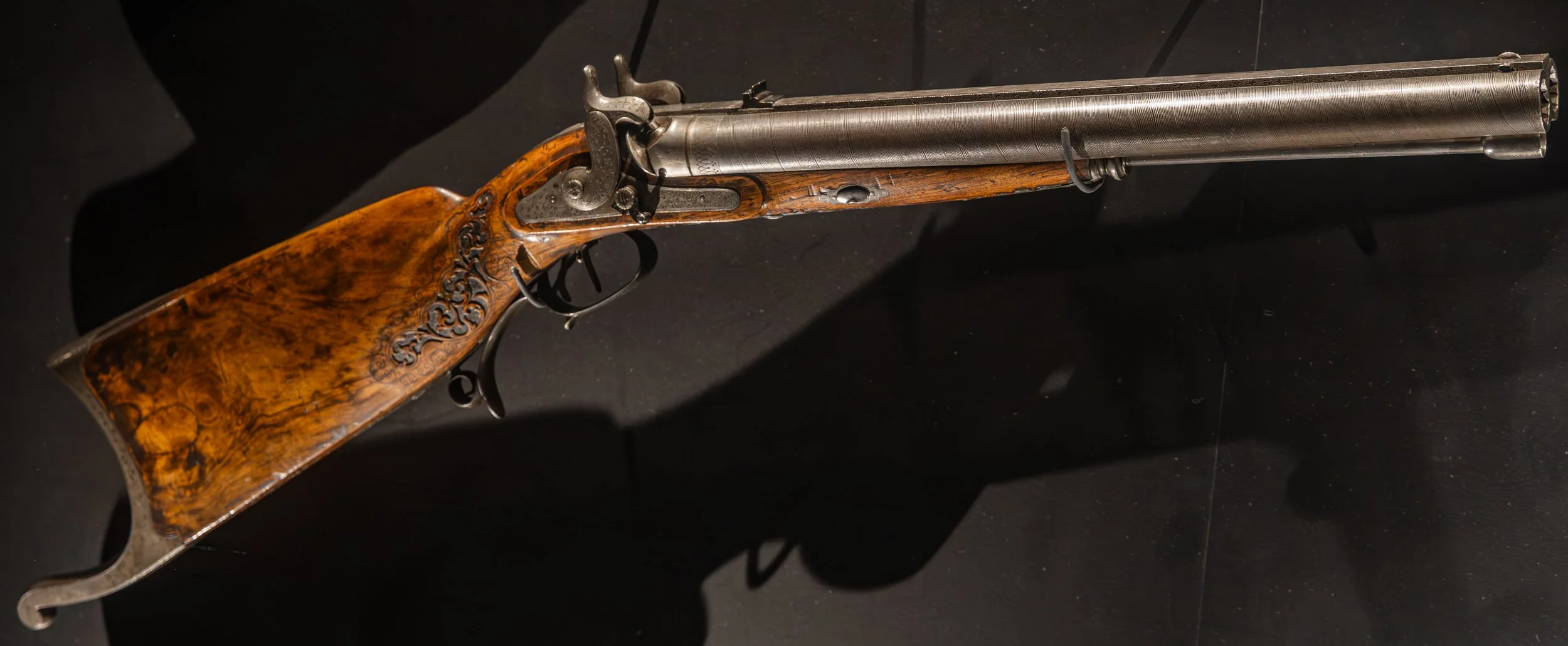 An image of a double-barrel percussion dangerous game rifle with damascus barrels and highly-figured walnut stock.