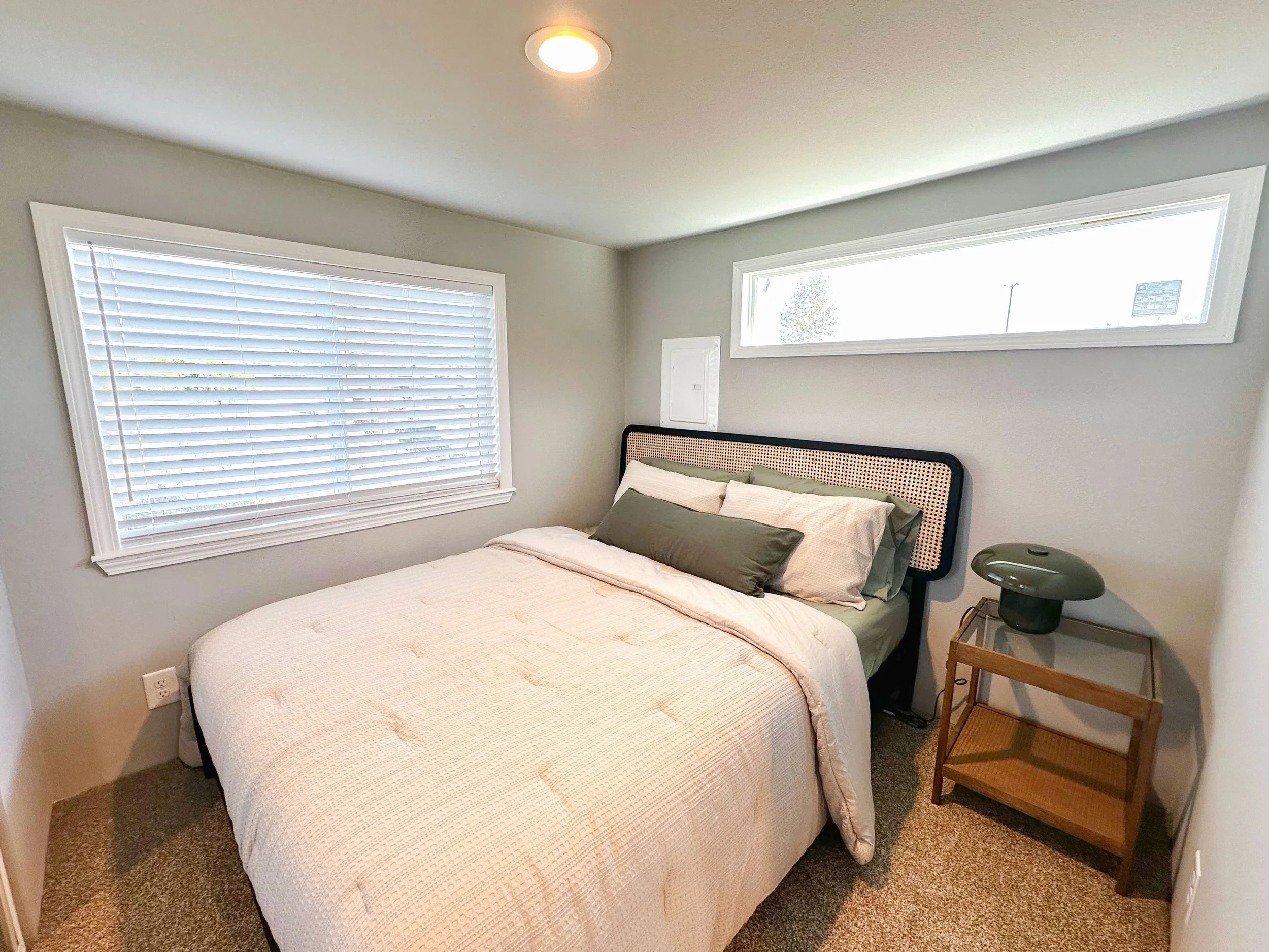 Snohomish Hemlock model bedroom with queen bed, nightstand, and windows