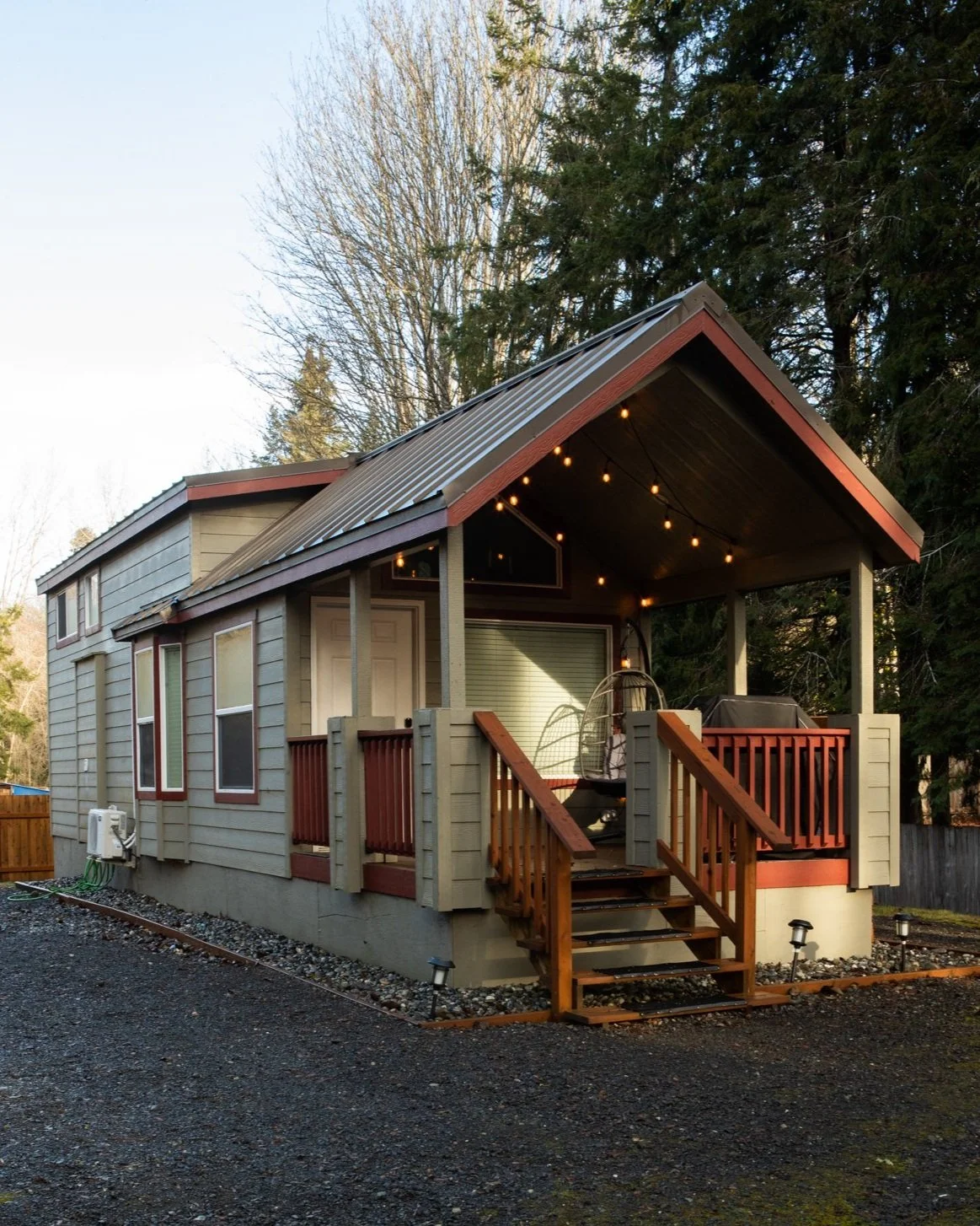 Tiny home with a wooden porch and string lights