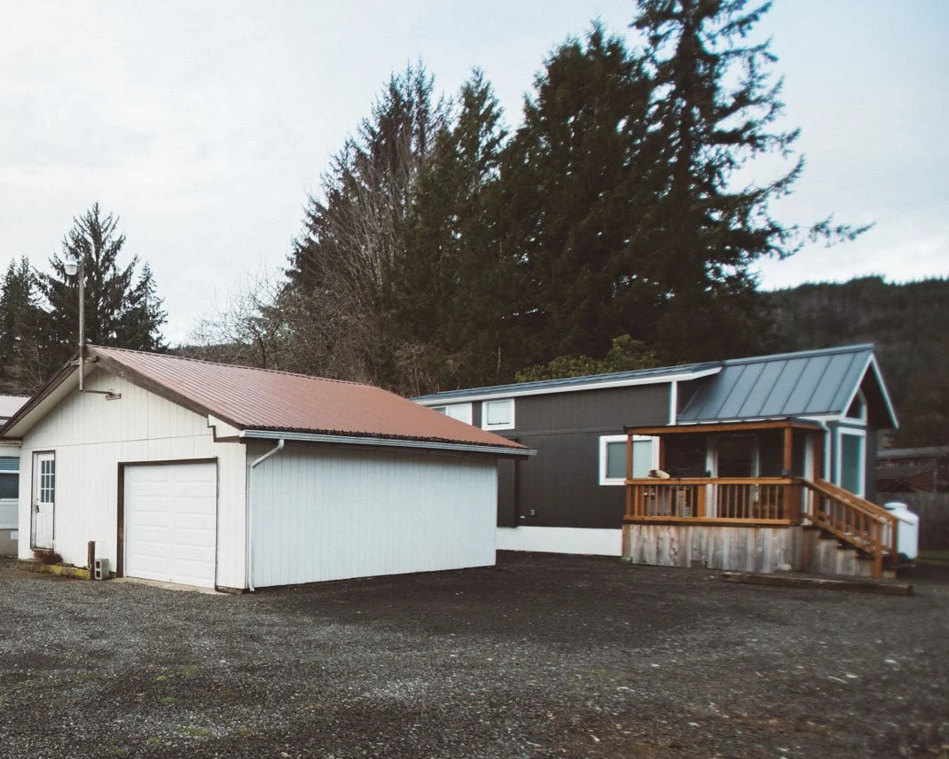 A park model tiny home being used as a backyard ADU behind a main house