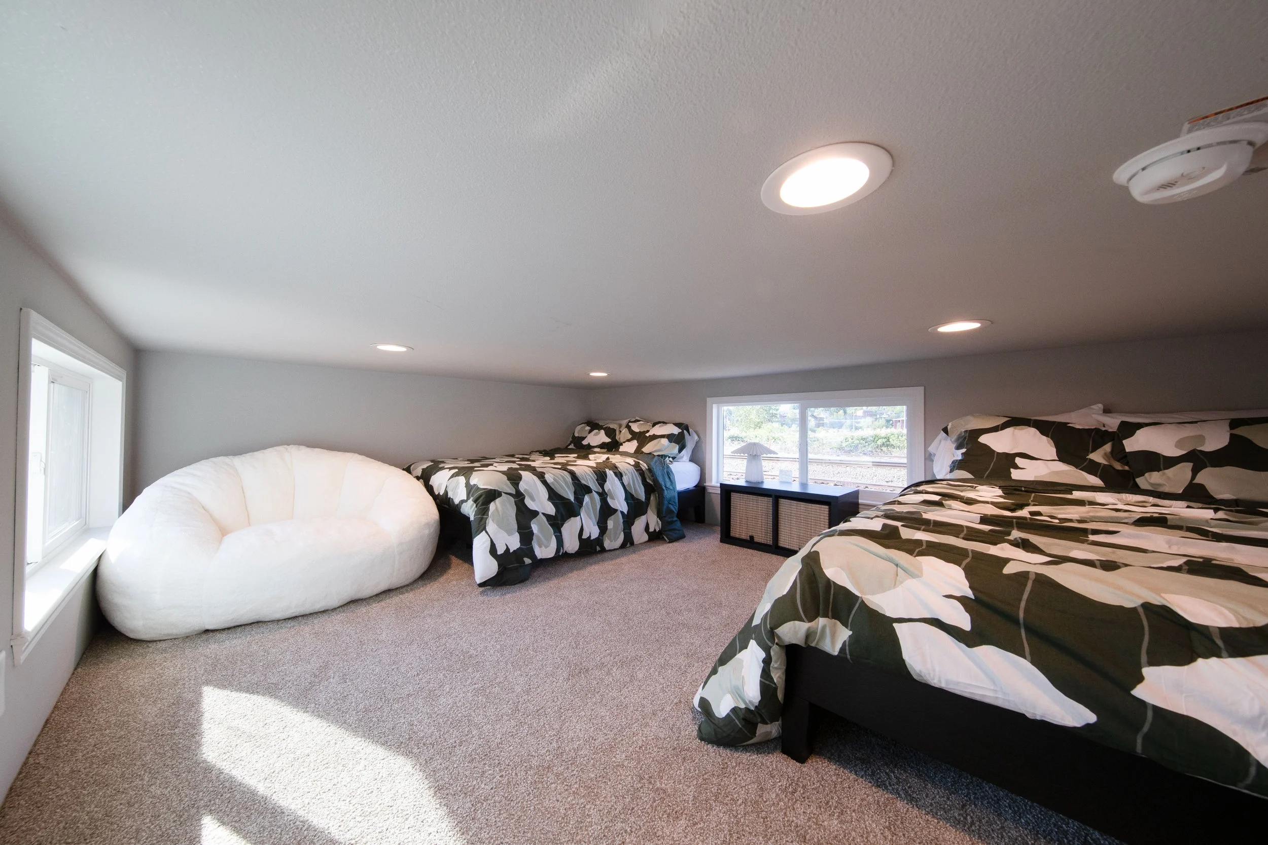 Snohomish Hemlock model loft with two double beds and large beanbag chair in corner