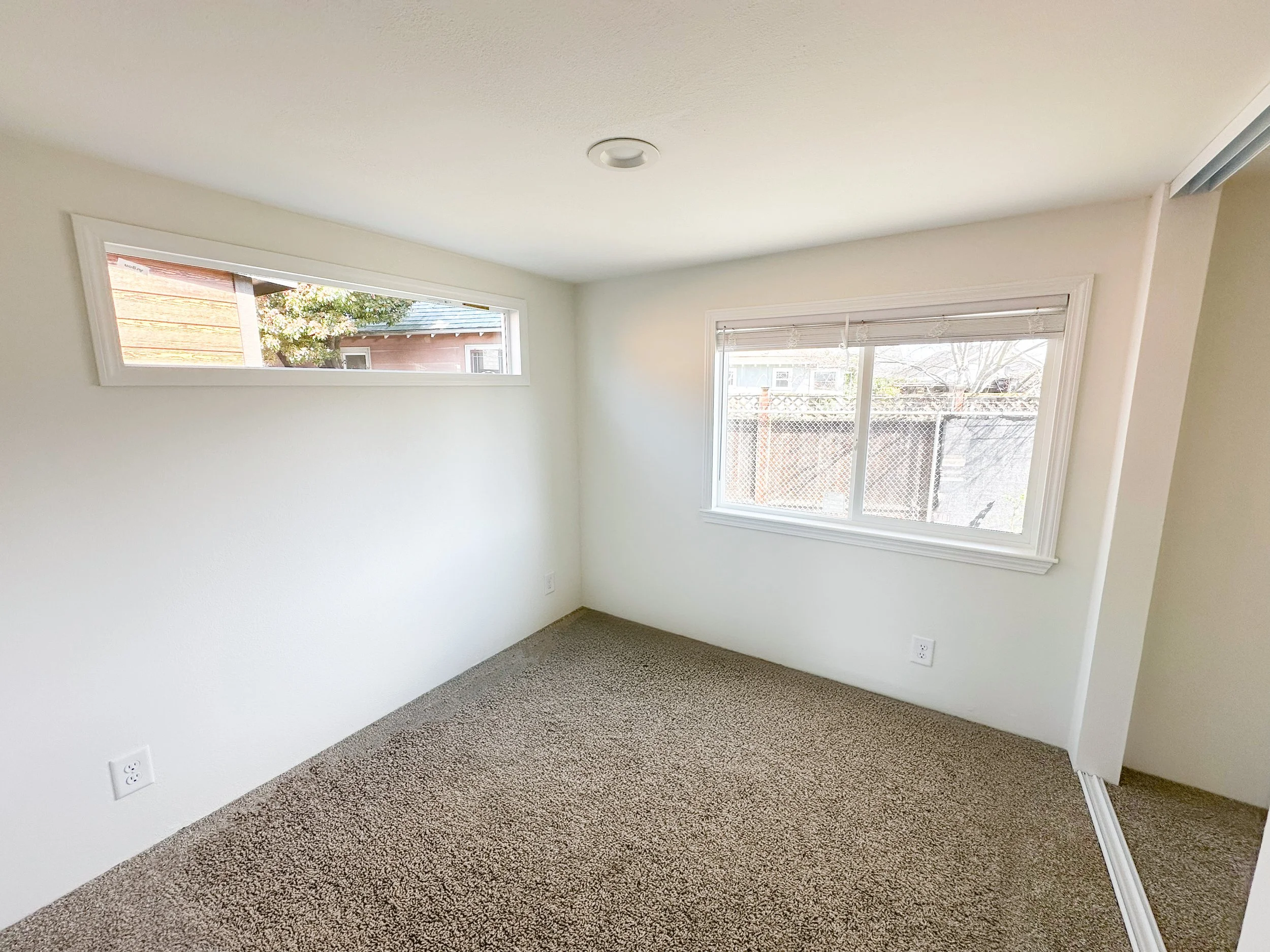 Bedroom with added transom window (mirrored closet doors to be installed after delivery)