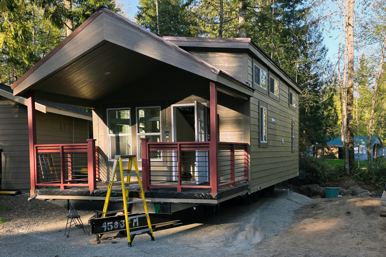 Tiny house with red and green colors in a wooded setting
