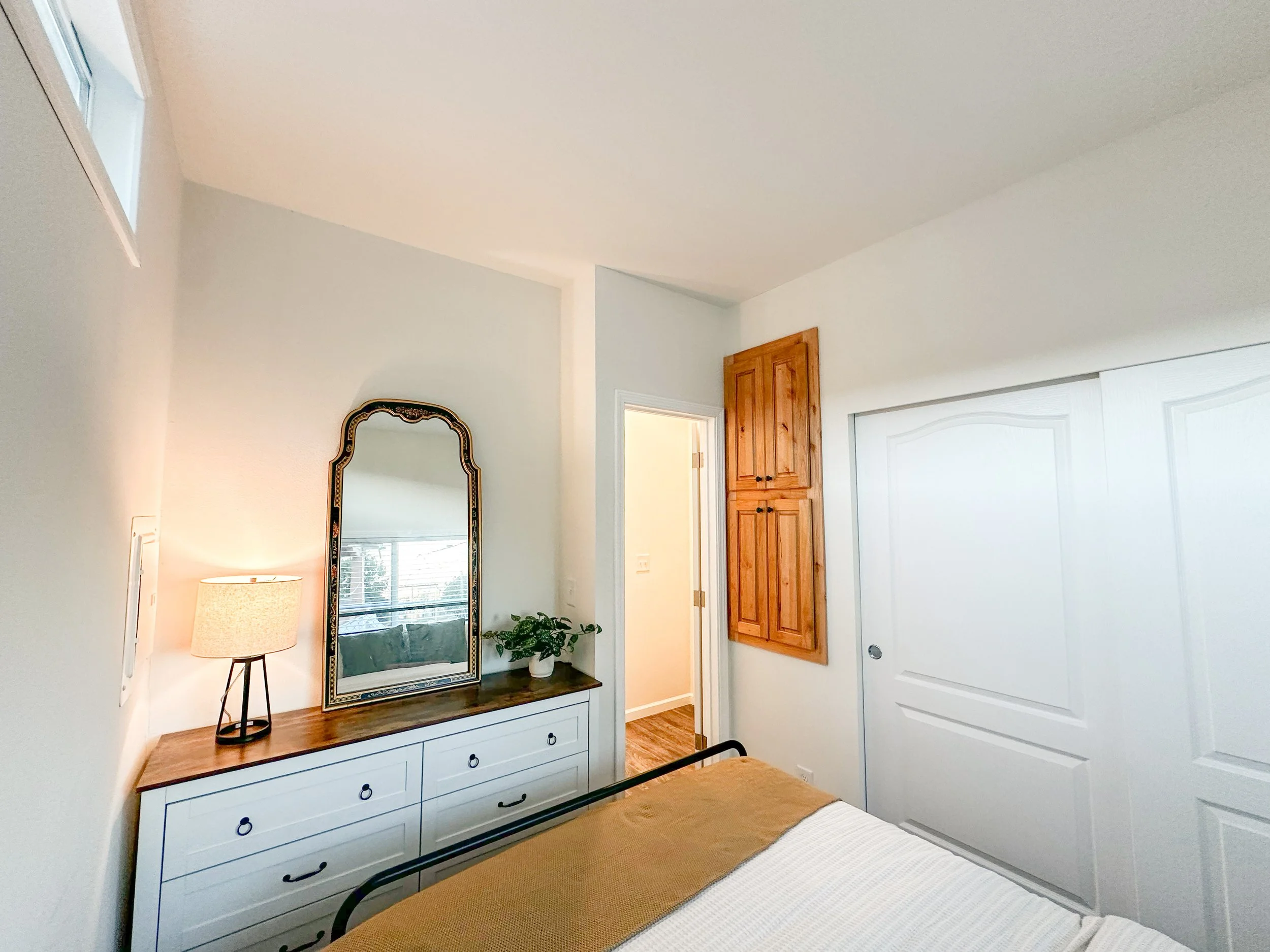 Willow bedroom showing dresser nook with mirror and lamp. Built-in linen cabinets and large closet offer abundant storage