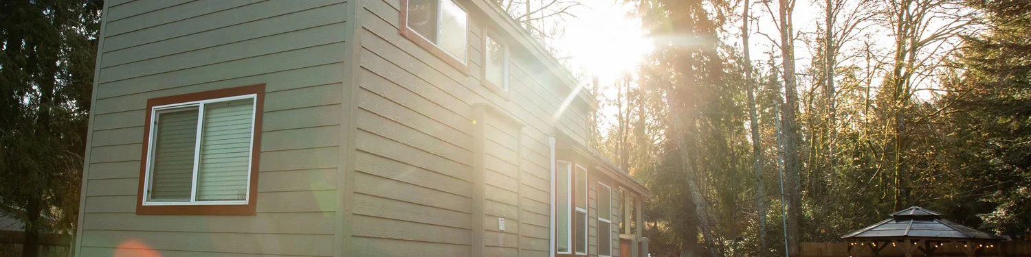 A NW Tiny Homes park model RV tiny home among tall evergreens