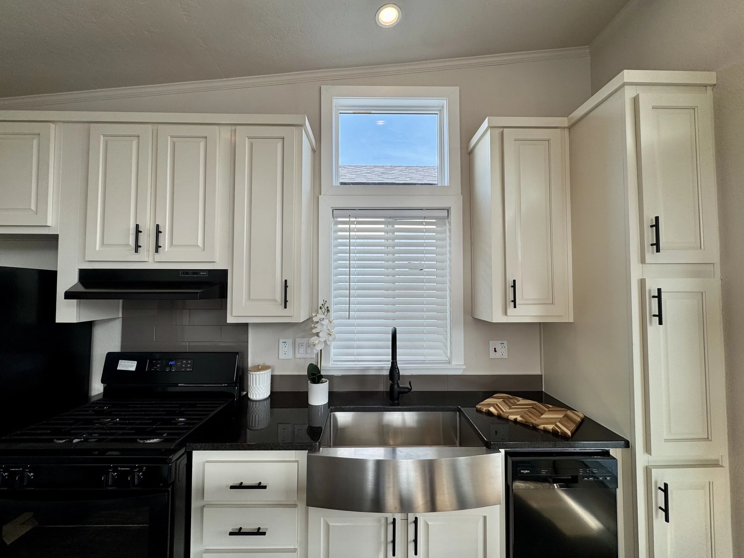 Ponderosa kitchen with white cabinets, stainless steel farmhouse sink, and dishwasher