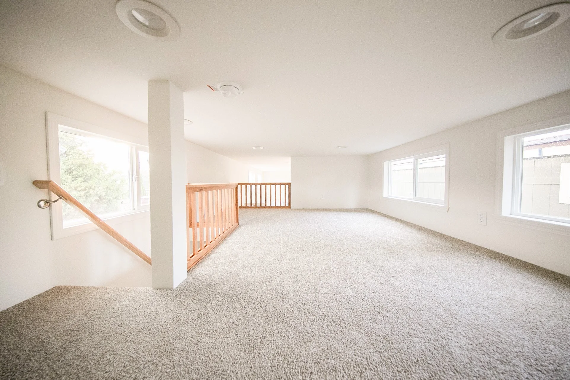 Loft facing stairway and living room/kitchen wall