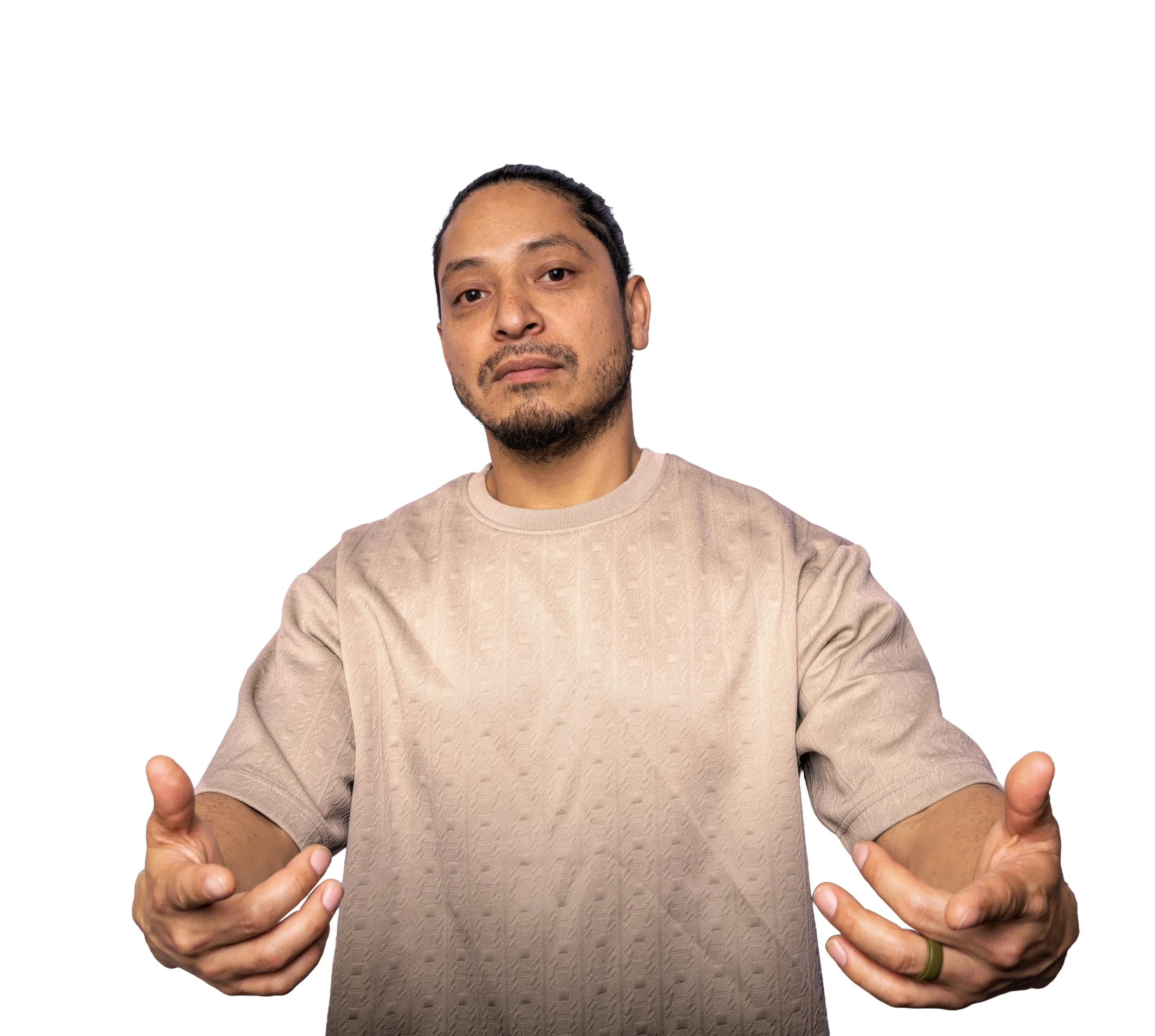 A man with short dark hair and a goatee is showing his thumbs up with both hands, wearing a beige textured shirt, against a white background.