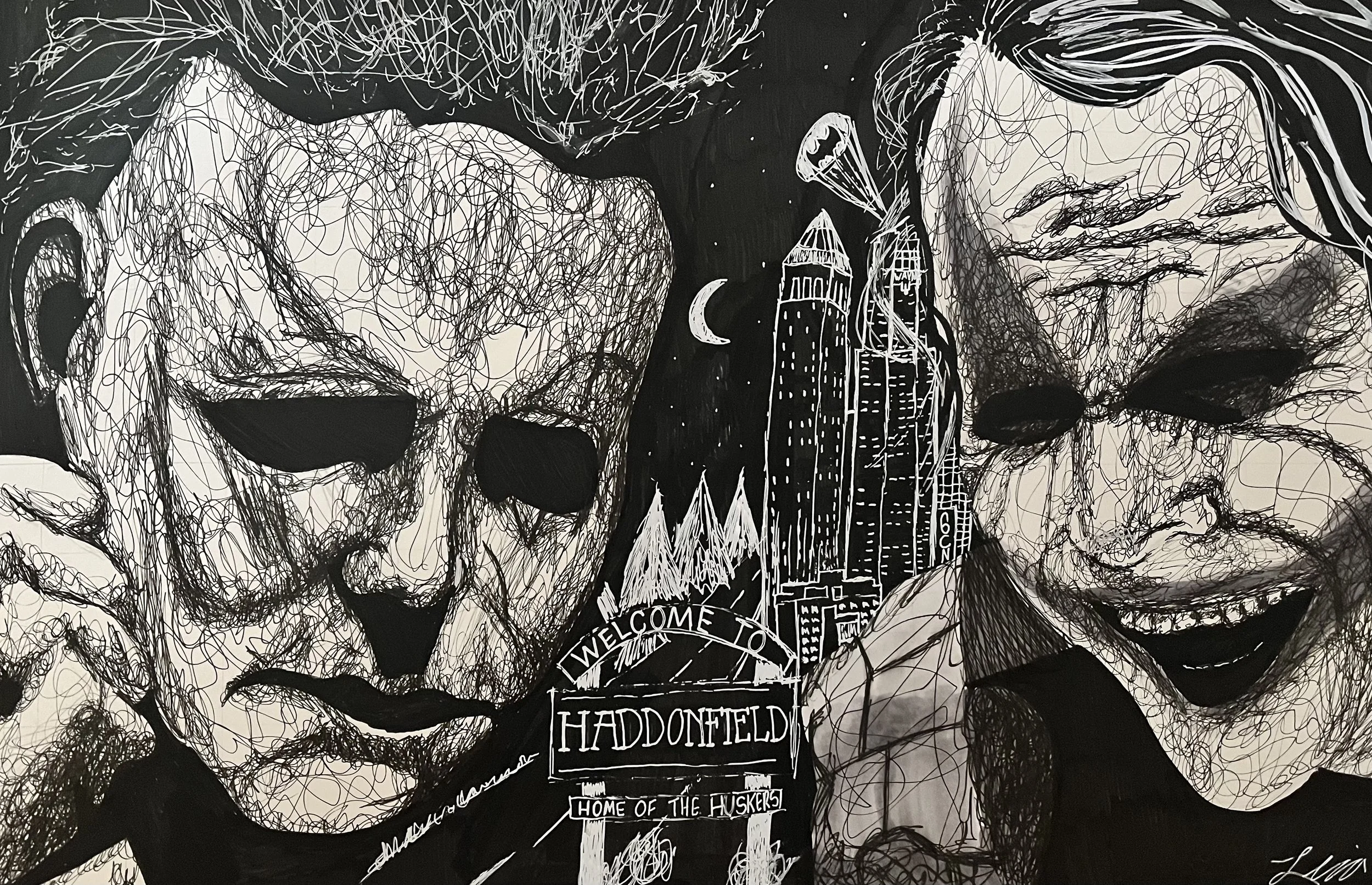 A black and white drawing of two men with closed eyes, surrounded by trees and a cityscape in the background. The drawing includes a sign that reads 'Welcome to Haddonfield, home of the Huskers'.