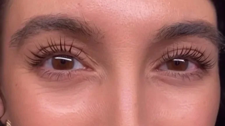 Close-up of a person's eyes and eyebrows, showing long eyelashes and well-groomed eyebrows.