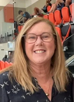 Polley, smiling, wearing glasses