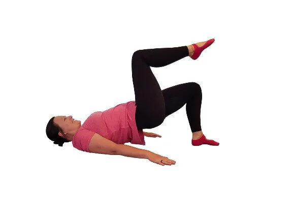 Pilates instructor in bridge position strengthening glutes