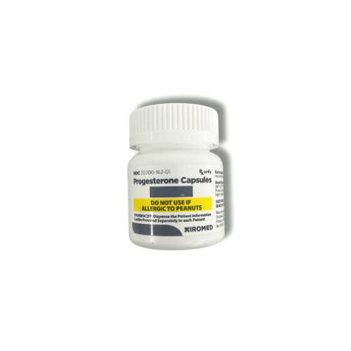A bottle of progesterone capsules with a white screw cap, labeled with caution about allergic reactions to peanuts.