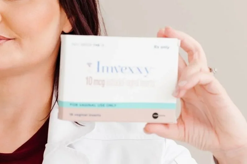 Person holding a box of Invery 10 mg medication, partially obscuring their face.