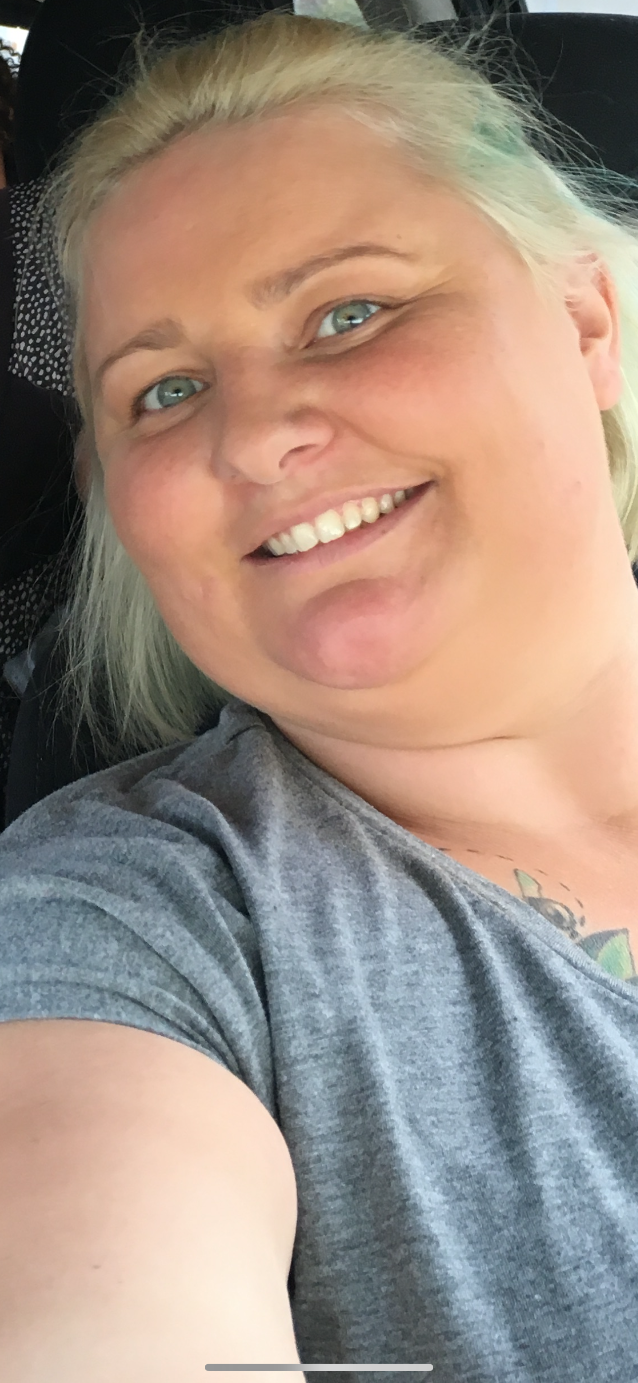 Person taking a selfie wearing a gray shirt.