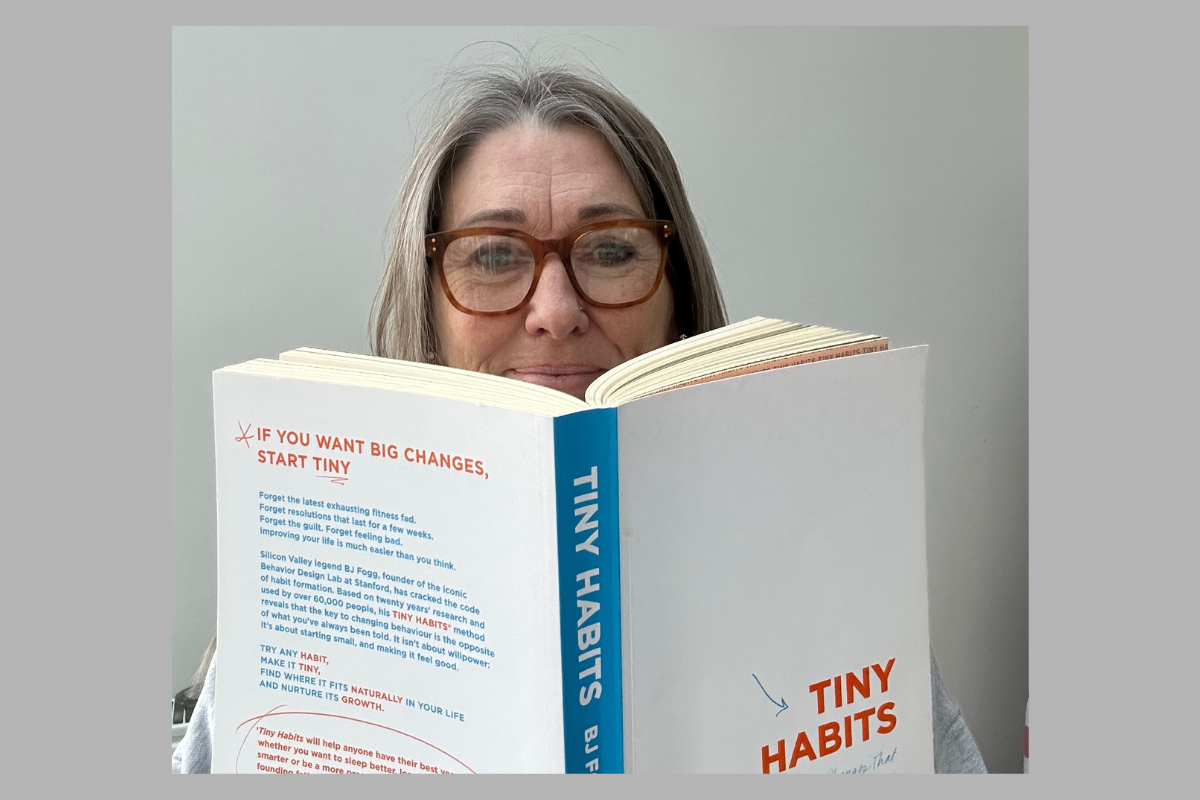 Nicky Massey women’s life coach reading Tiny Habits by BJ Fogg, reflecting on small habit changes and confidence building for women