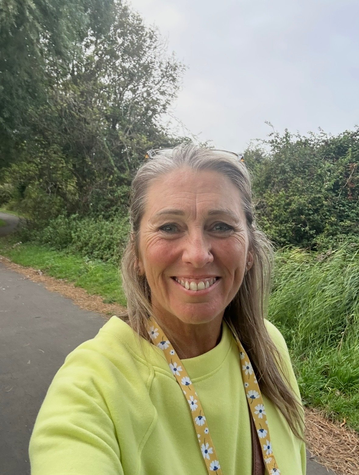 Nicky Massey smiling outdoors on a walking path, at ease and present in the moment
