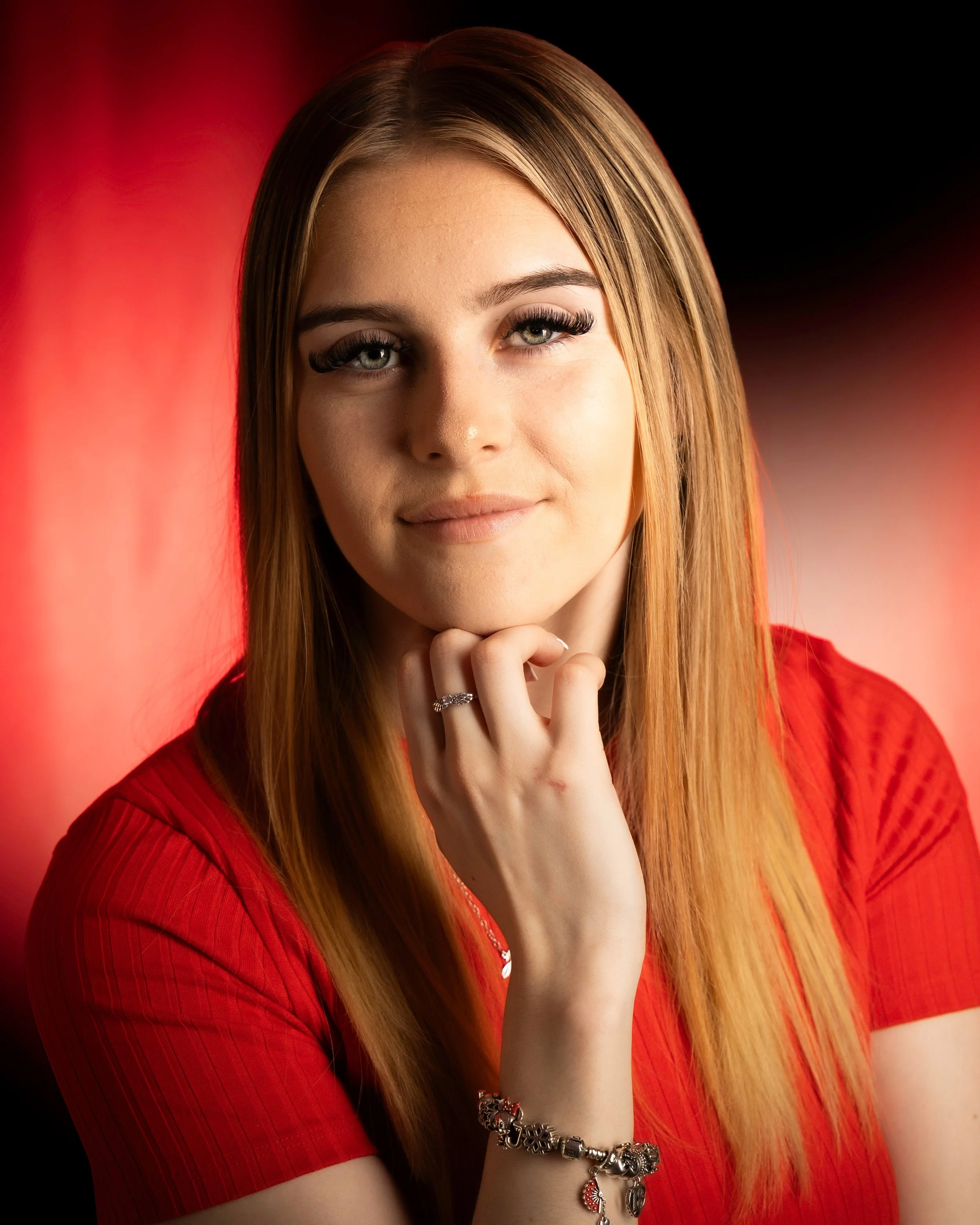 Warm-toned female actor headshot with red backlight. Professional creative portraits in Southend by Matt Daley.