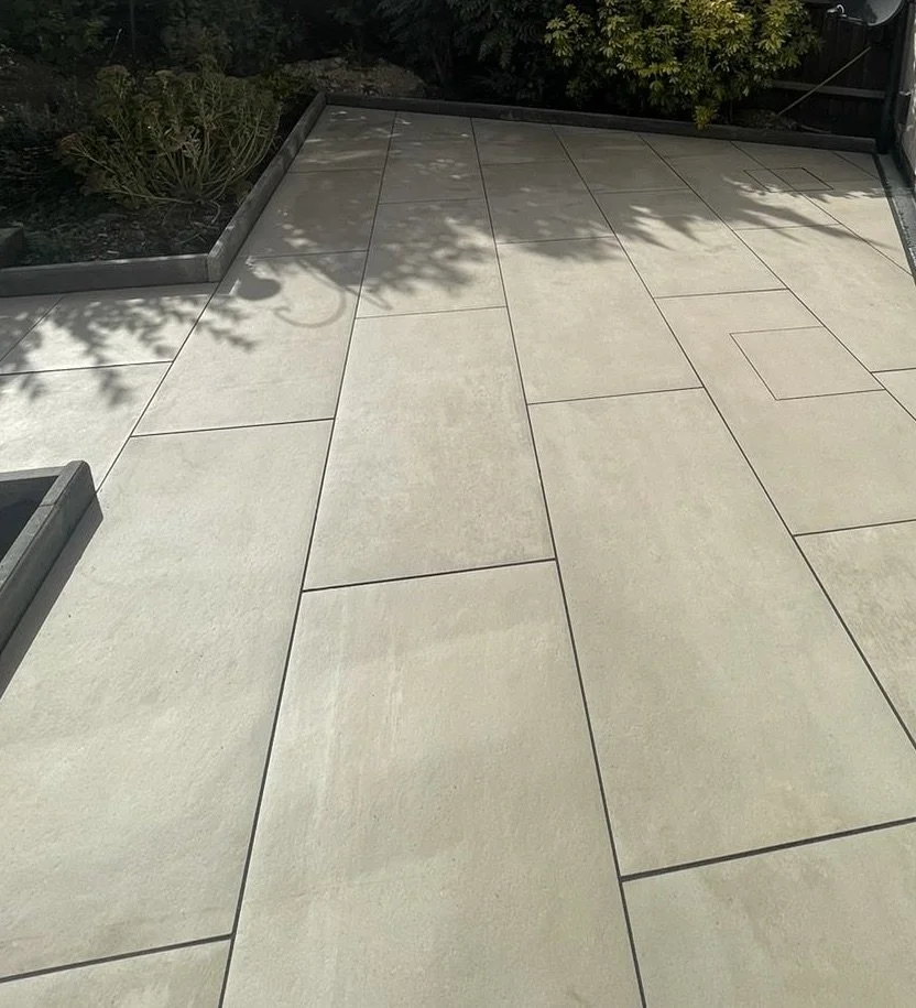 Przestronny taras wyłożony dużymi płytami porcelanowymi w kolorze kremowym, zapewniający gładki, nowoczesny wygląd oraz lekką i przestronną atmosferę. Trwały, odporny na warunki atmosferyczne i łatwy w utrzymaniu.
